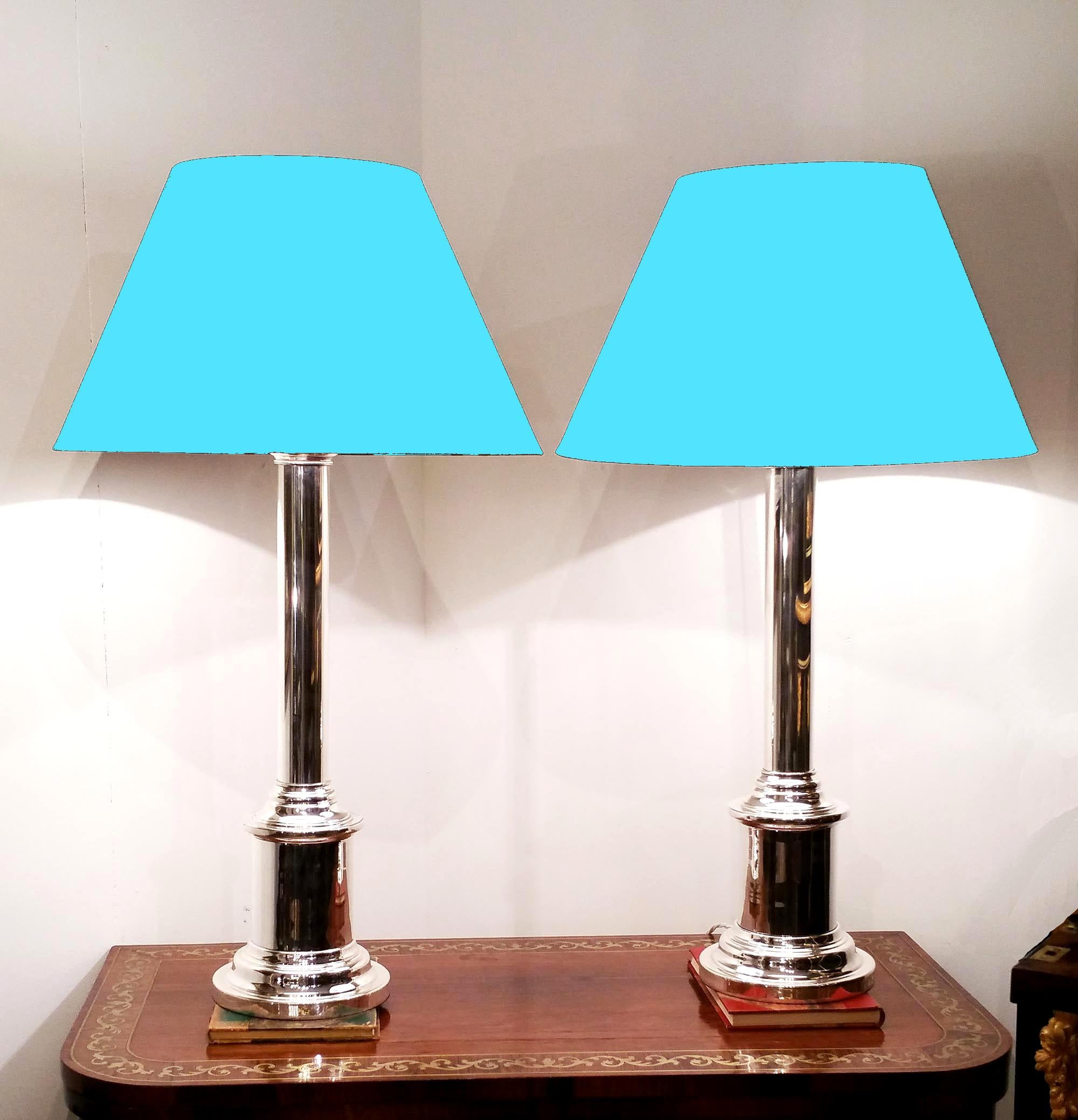 These sleek and elegant silver plated table lamps have a slender column design with bayonet fittings. Each light measures 6 in - 15 cm diameter on the base with a height of 25 in - 63.5 cm, and with a sample shade shown, measures approximately 32 in