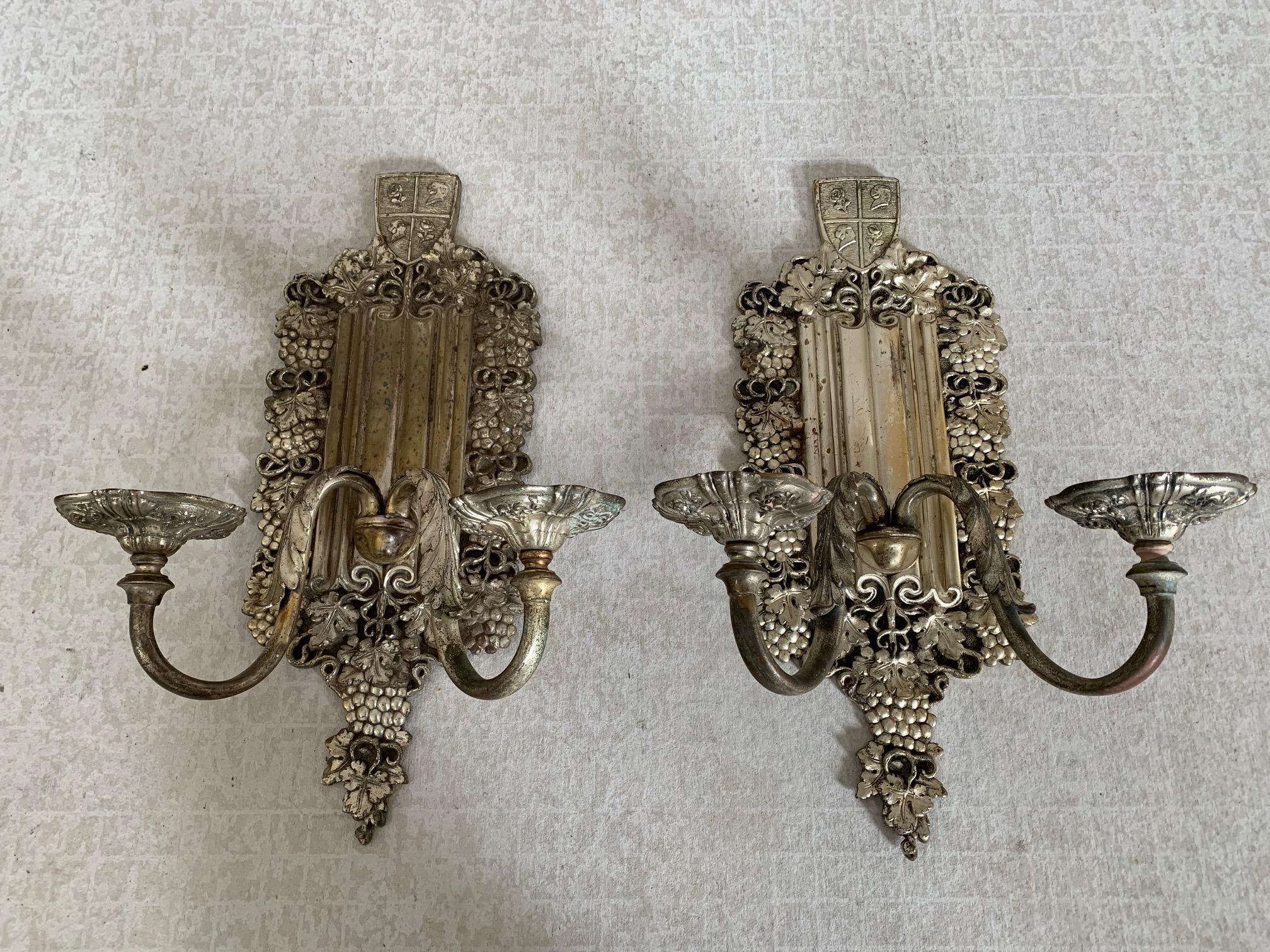 Silver plated bronze, 2-arm sconces with grape border, linen-fold backplate and heraldic griffin and rose shield.
Attributed to E. F.Caldwell, New York, circa 1925.
Plating is worn in areas but largely intact. Custom wiring inclusive.