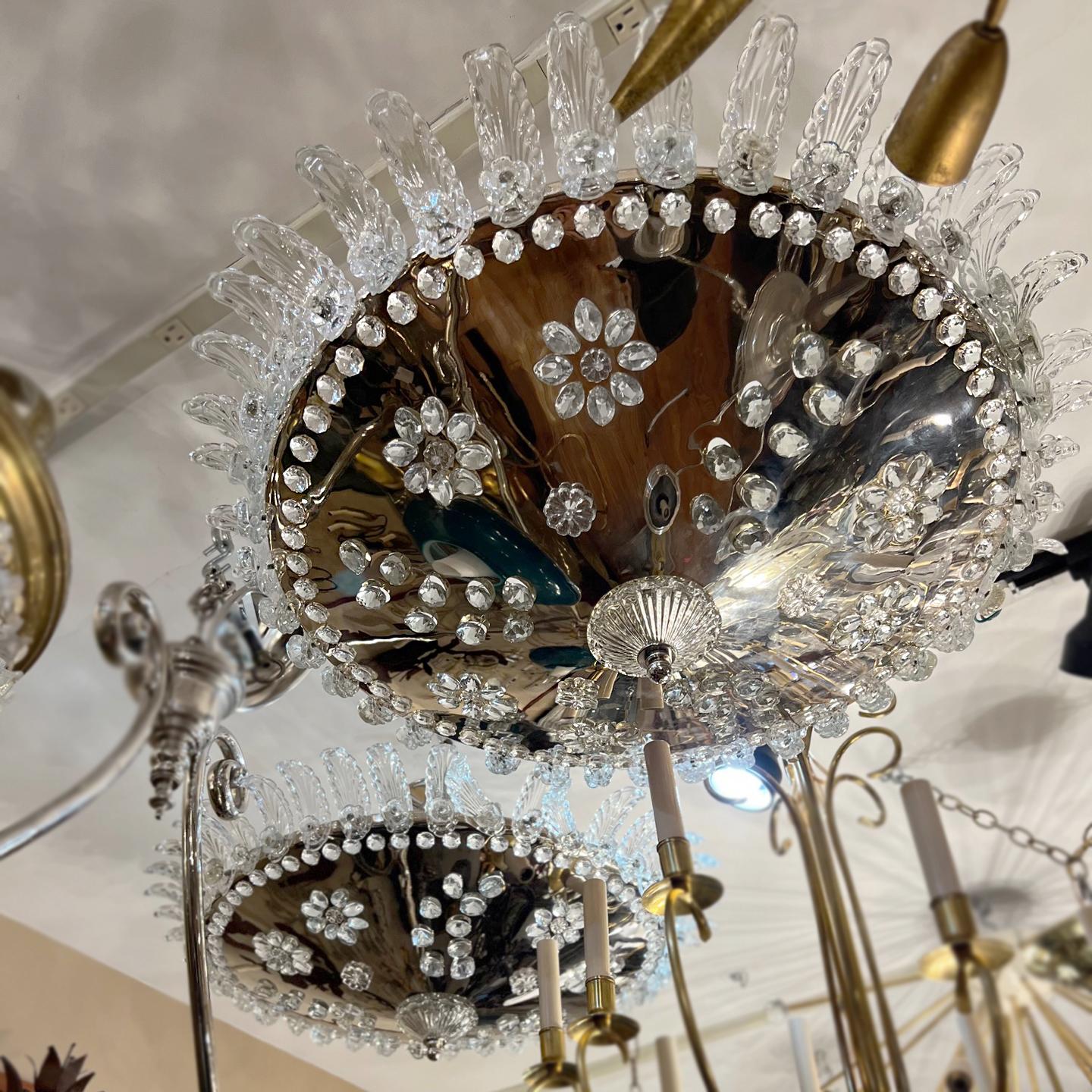 Pair of French circa 1940s silver plated light fixtures with 8 interior candelabra lights and pierced body with crystals rosettes. Each body is crowned with molded glass palmettes. Sold individually.

Measurements:
Height (drop): 16