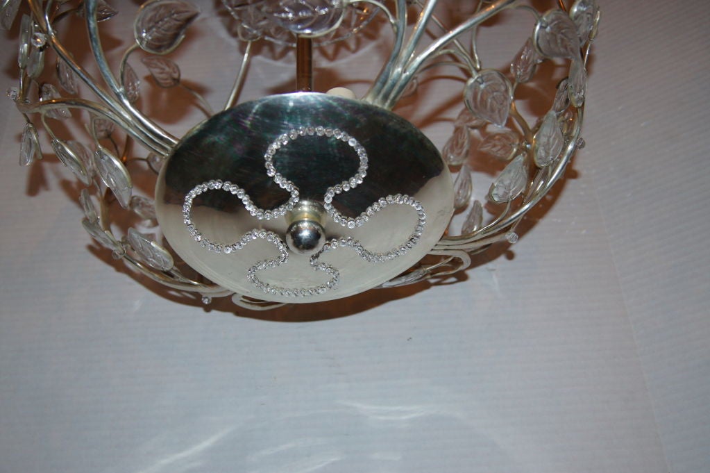 A pair of circa 1940's French silver-plated light fixture with molded glass leaves and flowers and four interior lights. Sold individually.

Measurements:
Diameter 18
