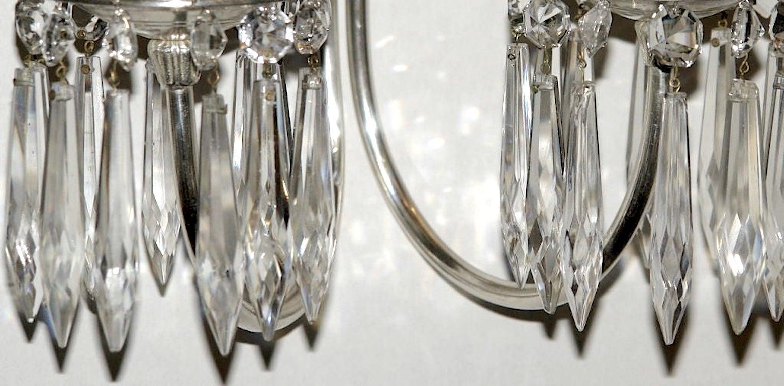 A pair of circa 1920's American two-arm mirror-back silver-plated sconces with crystal drops.

Measurements:
Height: 21