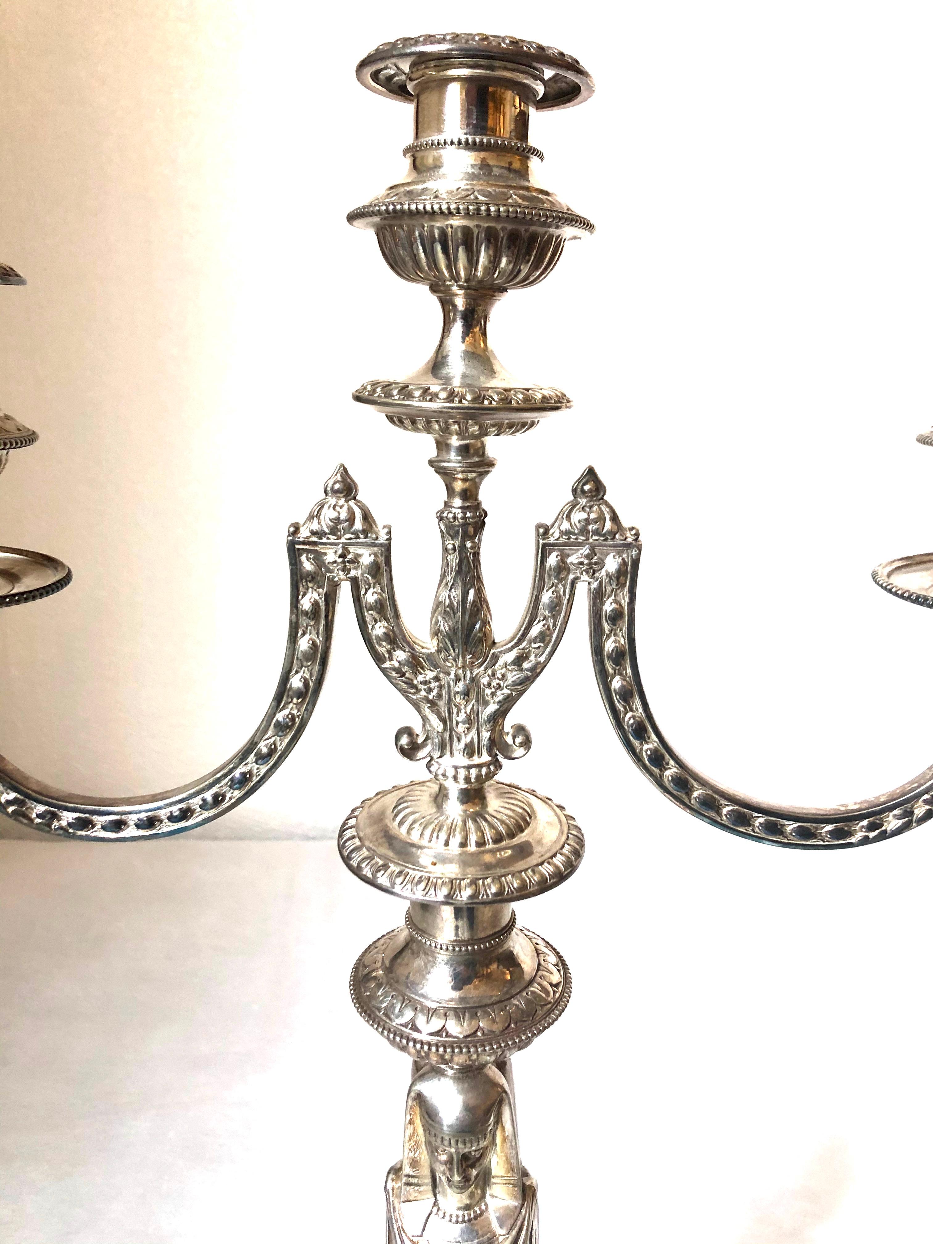 A pair of Victorian silver plated three-light candelabra, 1875

Lobed vase-shaped capitals with beaded borders and shield and dart rims on two leaf-capped out swept arms with husk decoration, issuing below a central light, the knopped stems formed
