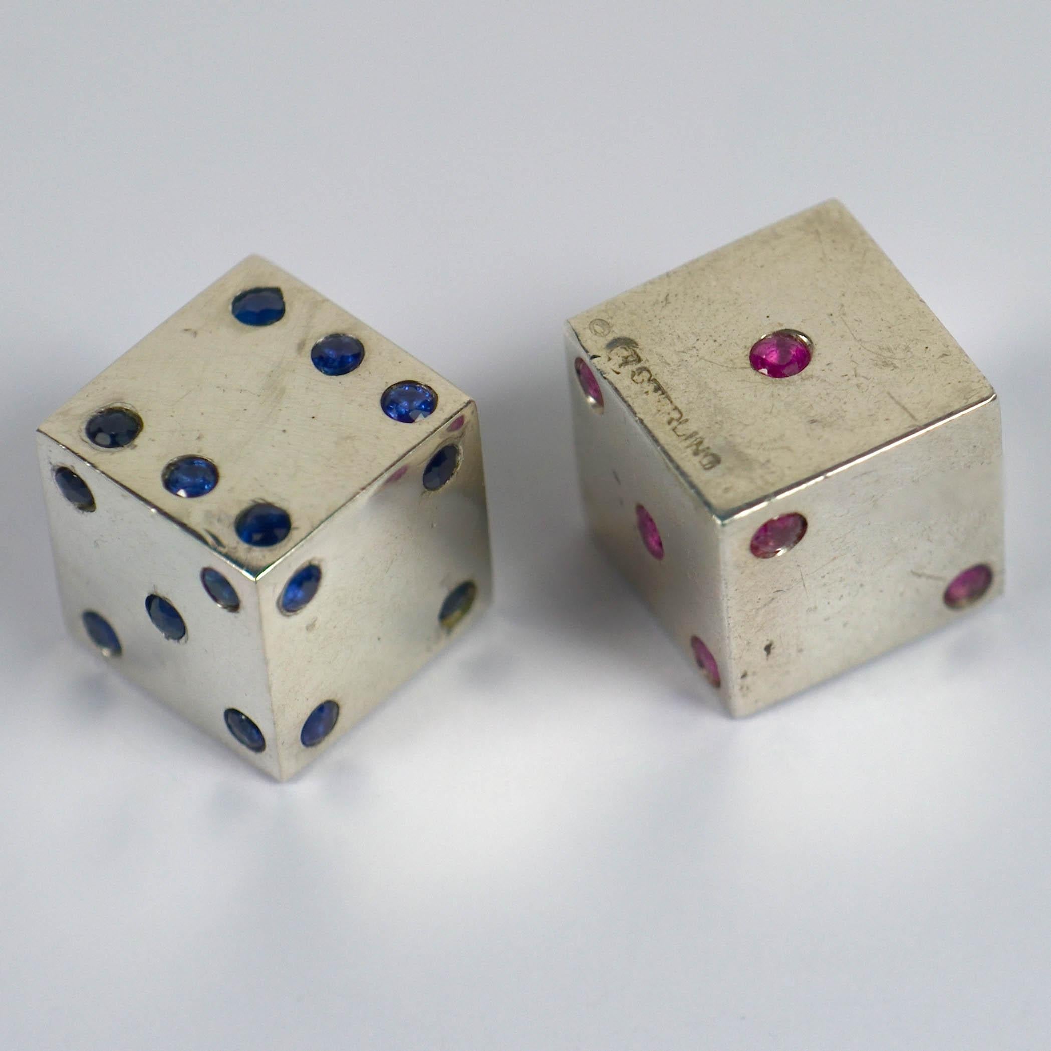 A fantastic pair of novelty French silver dice with the dots picked out in natural blue sapphires on one die, and natural rubies on the other. A lovely and unusual gambling set with great patina and a hefty feel in the hand. 1.5cm cubes.