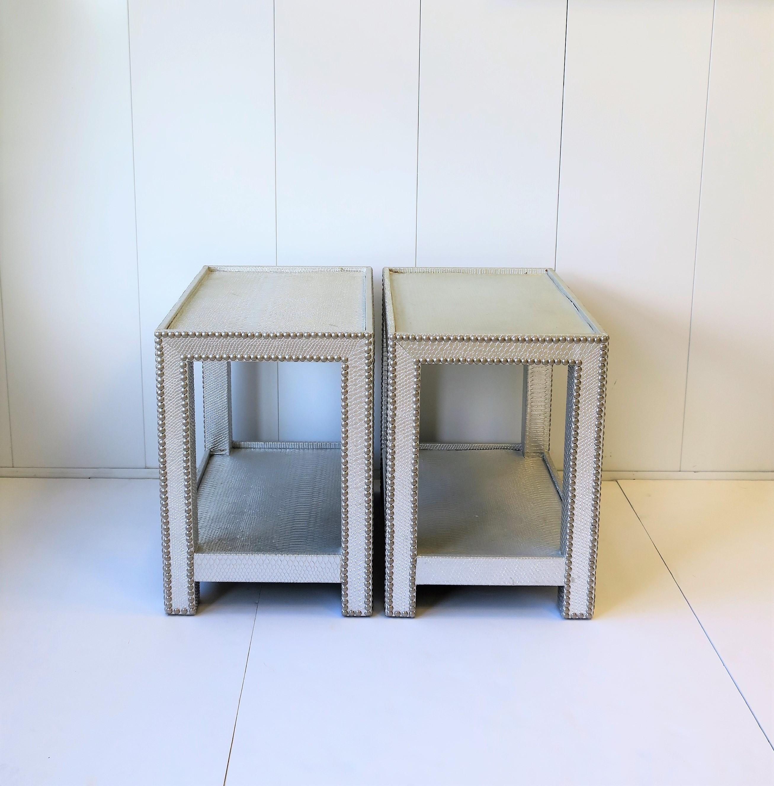 A beautiful modern style pair of silver embossed snakeskin-esque end or nightstand [night stand] tables with lower shelf. Table design style is also known as the 'telephone' table. Tables are wrapped in a snakeskin-esque material and finished with a