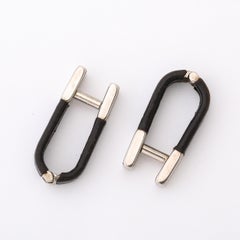 Paire de boutons de manchette en argent et cuir noir signés Prada