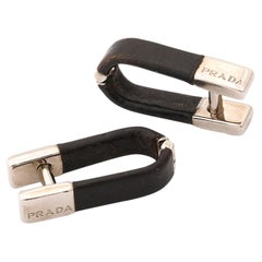 Paire de boutons de manchette en argent et cuir noir signés Prada