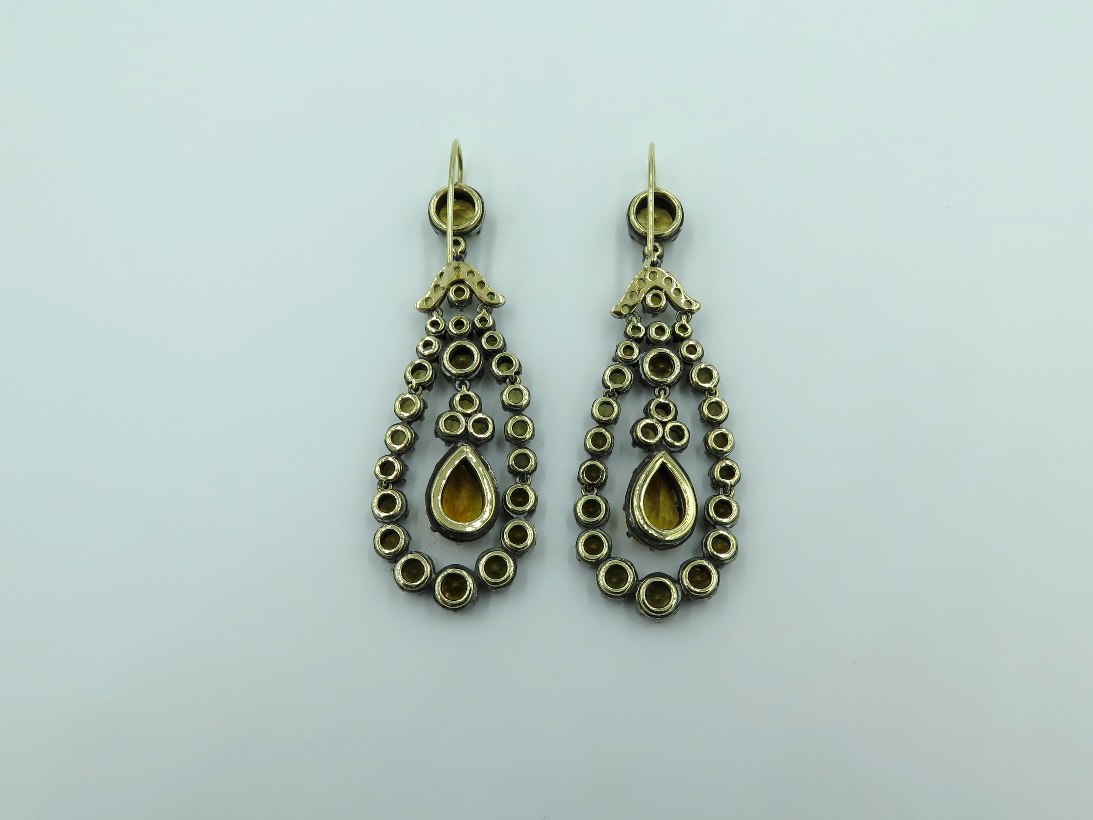 A pair of silver topped 18 karat yellow gold and citrine earrings. Designed by Marcella Ciceri in the Georgian style, of tear drop outline, set with circular cut citrine, centering a pear cut citrine. Sixty eight (68) circular cut citrine measure