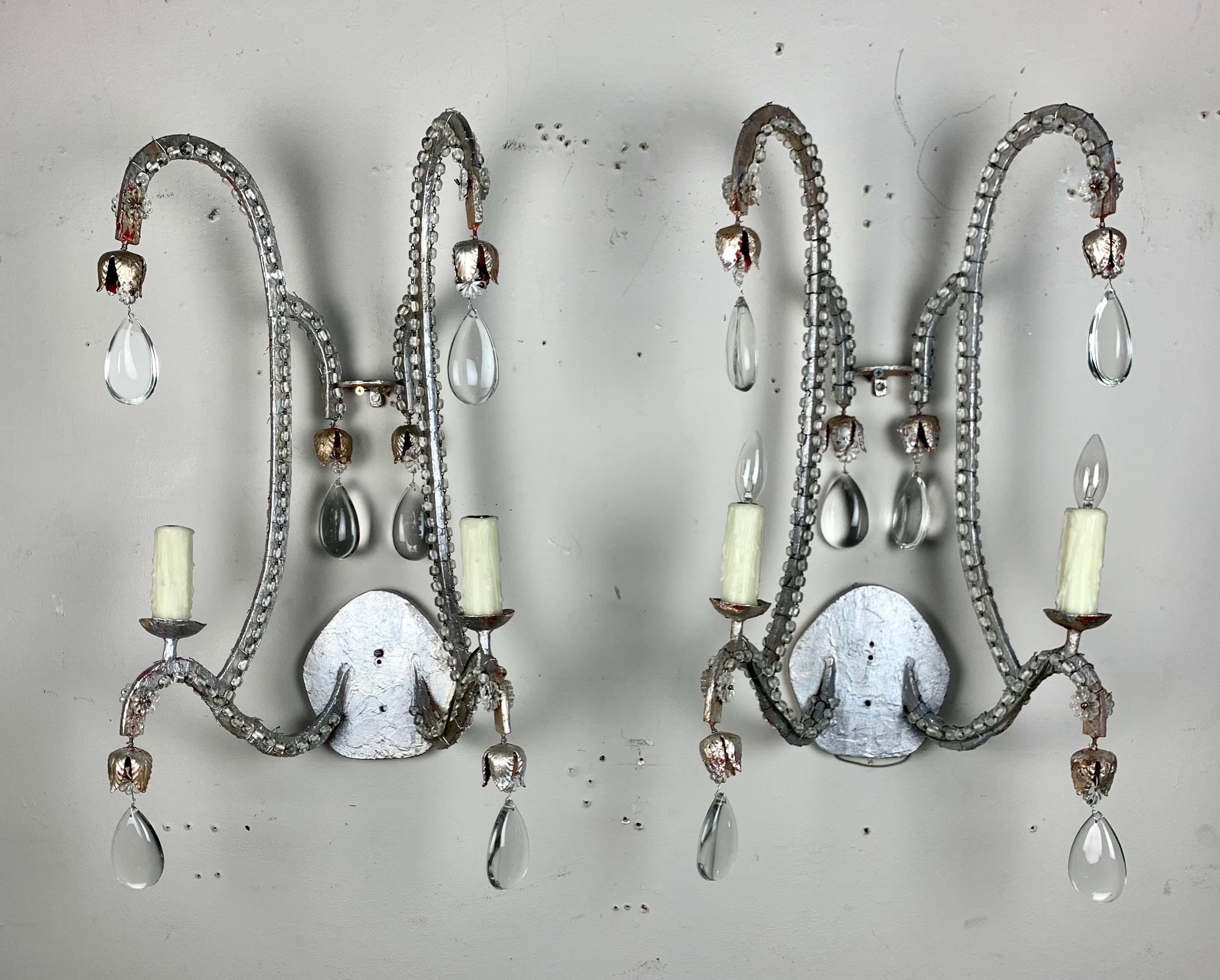 Pair of Italian silvered crystal beaded two light sconces. The sconces are newly rewired with drip wax candle covers. Clear almond shaped crystals can be seen throughout.