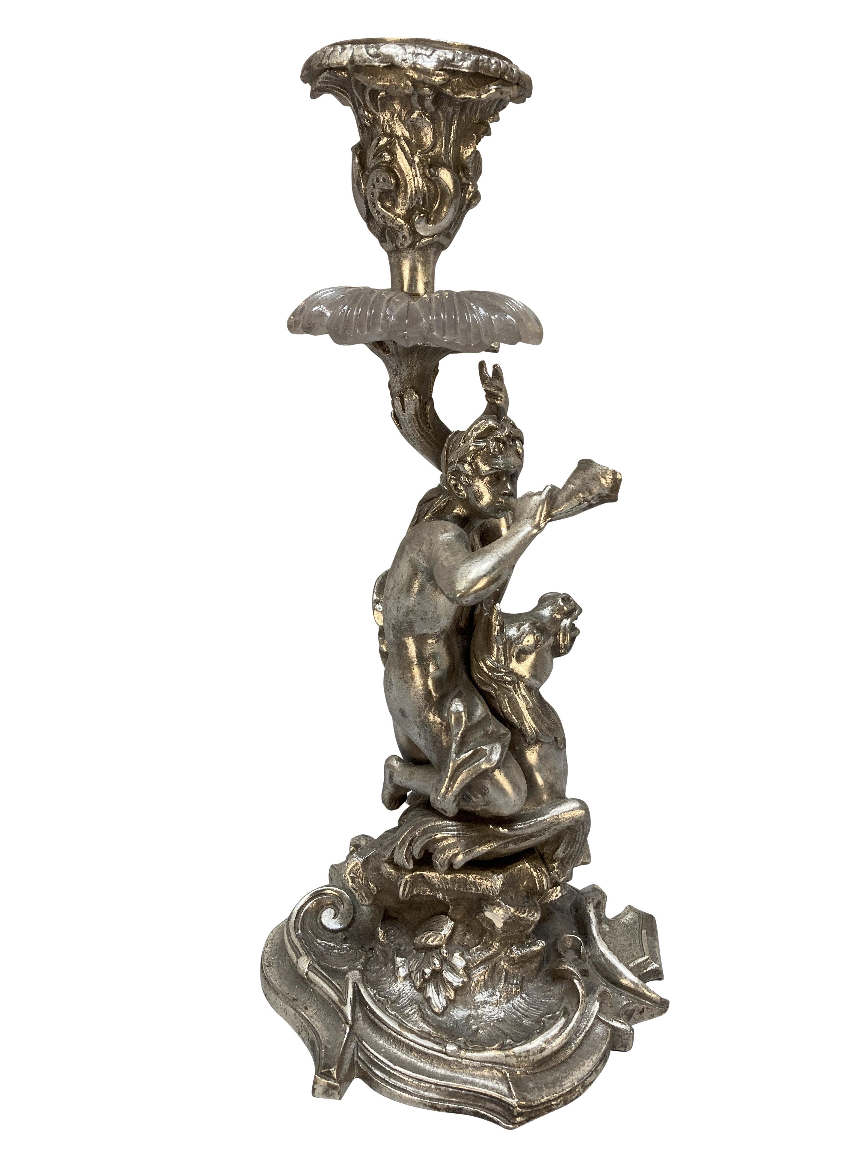 Coppia di candelieri francesi in bronzo argentato raffiguranti Tritone e Nereide. Si vede Triton cavalcare un cavalluccio marino e suonare un corno, mentre la Nereide, il suo interesse amoroso, cavalca una creatura marina. Con dettaglio in vetro.