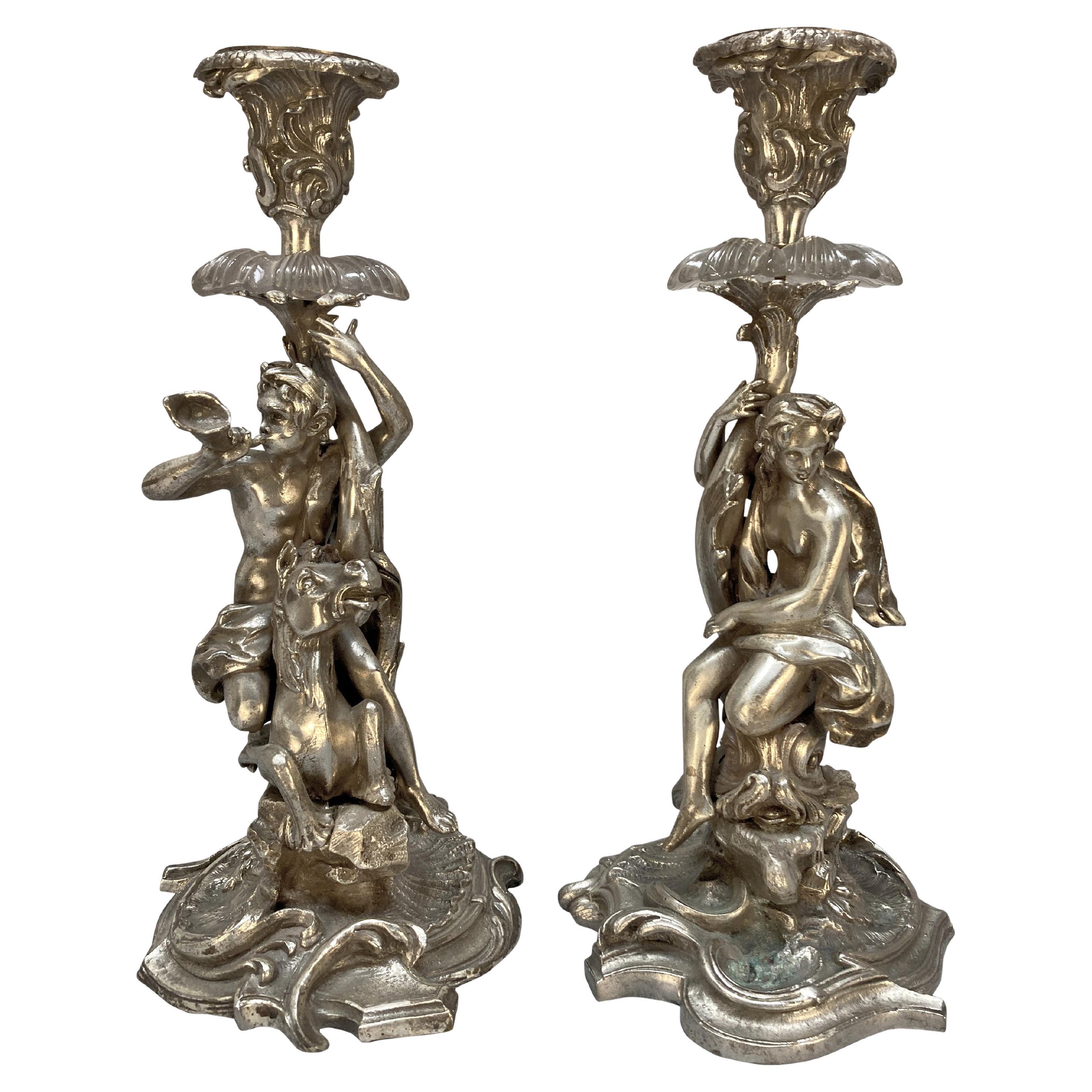 Coppia di candelieri in bronzo argentato raffiguranti Tritone e Nereide in vendita