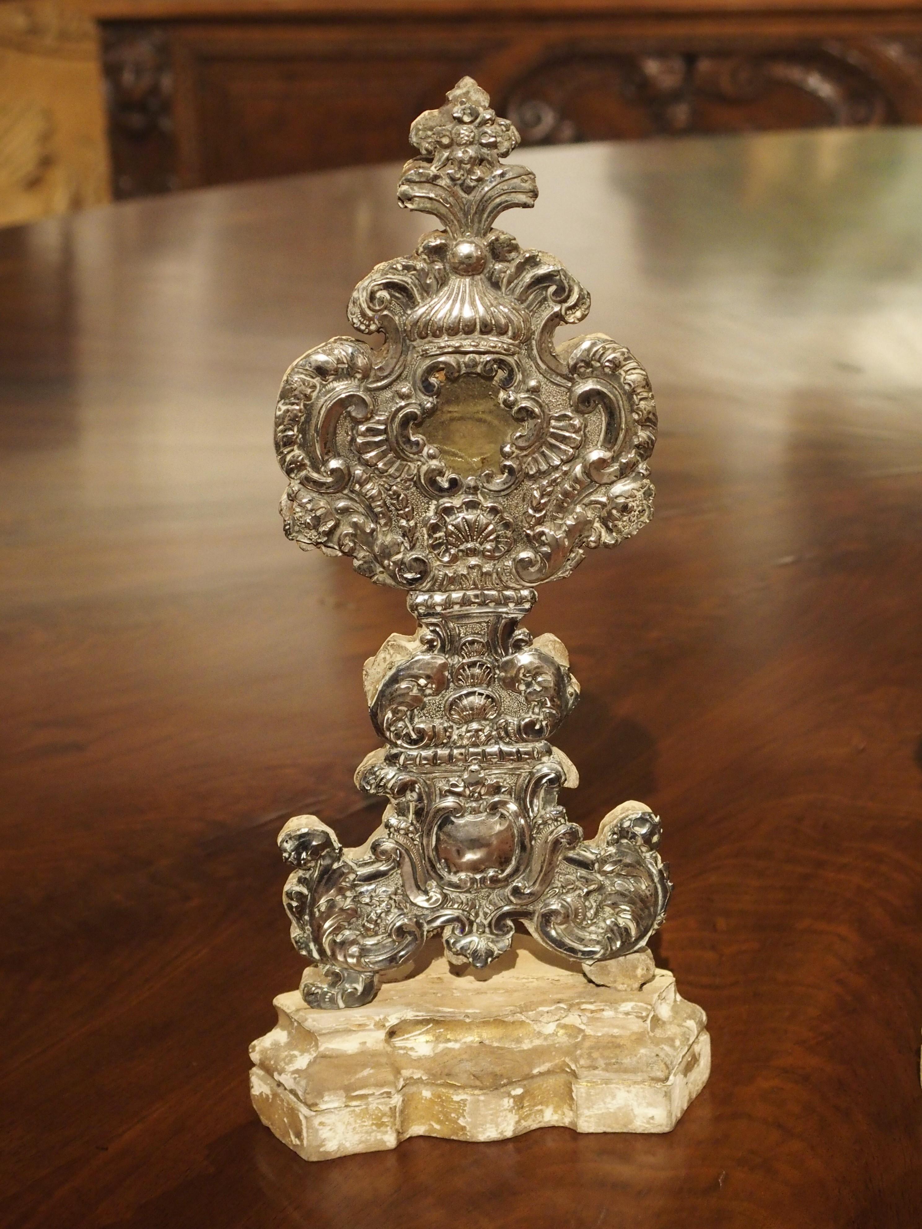 This pair of silvered wooden reliquaries are from France, circa 1750. The backs are still preserved by wax seals, indicating that the relics were never removed.

Each reliquary has an engraved piece of silver hammered onto the front of wooden