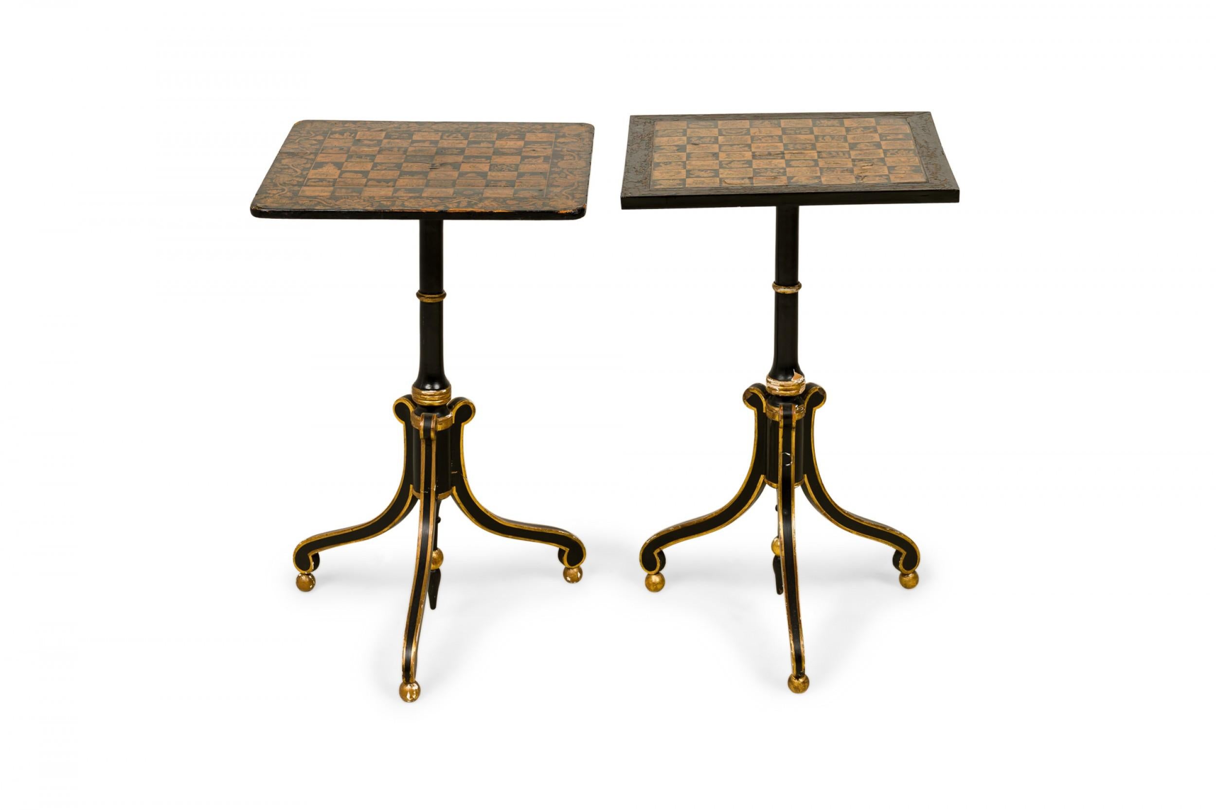 Pair of similar English Regency penwork chess tables with square wooden tops featuring painted chess boards in black and gold with elaborate designs in each square, surrounded by a foliate border, resting on pedestal bases with three gold-trimmed