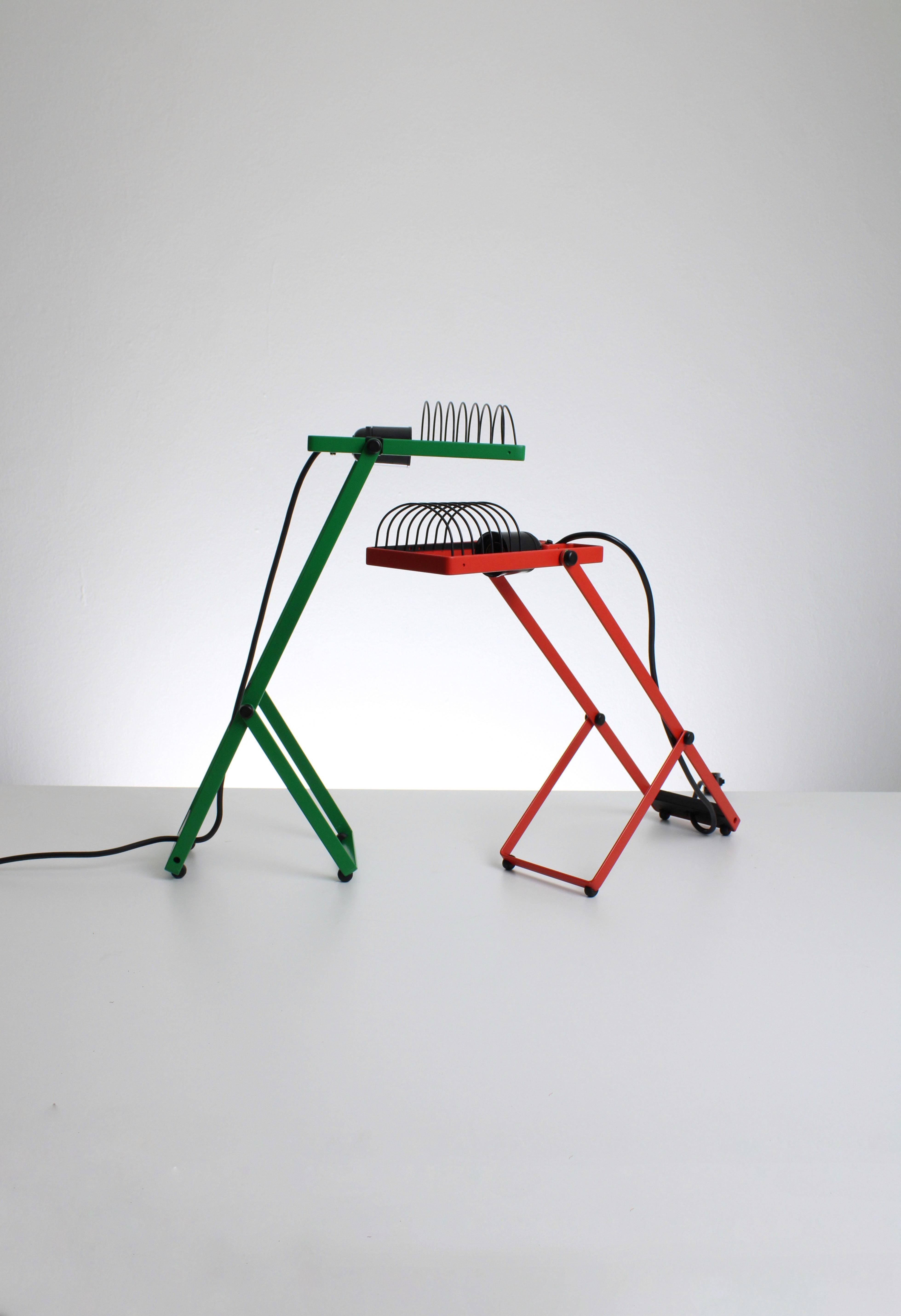 Set of two Sintesi desk lamps. Designed by Ernesto Gismondi for Artemide in the 1960s. Both of the lamps are from the first edition. New old stock including original box. This set includes an orange and green desk lamp. 

Both lamps are equipped
