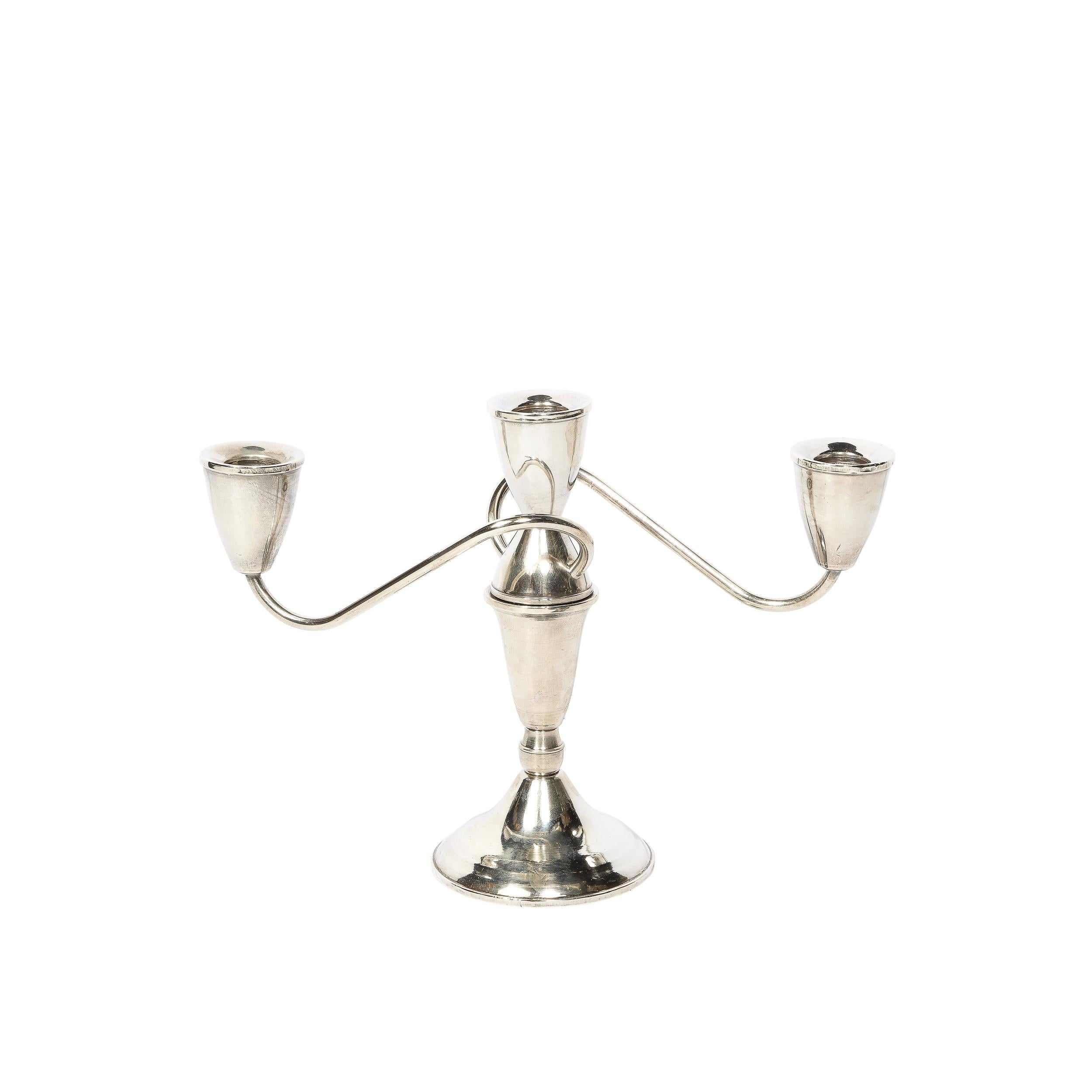 This pair of sinuous  sterling candelabras from the middle of the 20th century manufactured by Duchin Creations. The central candle holders rise from an elegantly tapered and streamlined base, and two rods extend from the central pillar taking