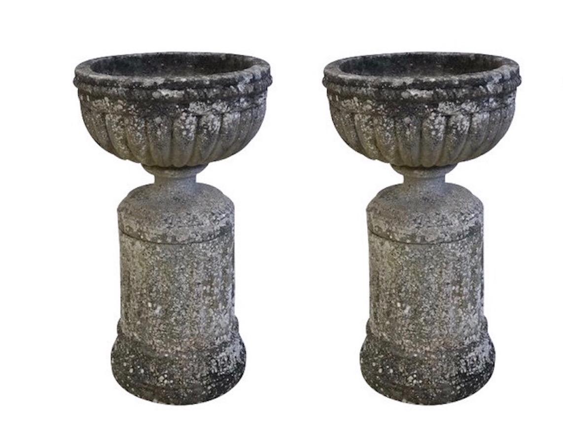 1900 pair of composition stone urns on plinths by Sir Edwin Lutyens from Plumpton Place Estate. 
Natural patina due to lichen unique to the East Sussex region of England
Four pair are available.
Extremely unusual to find available four matching