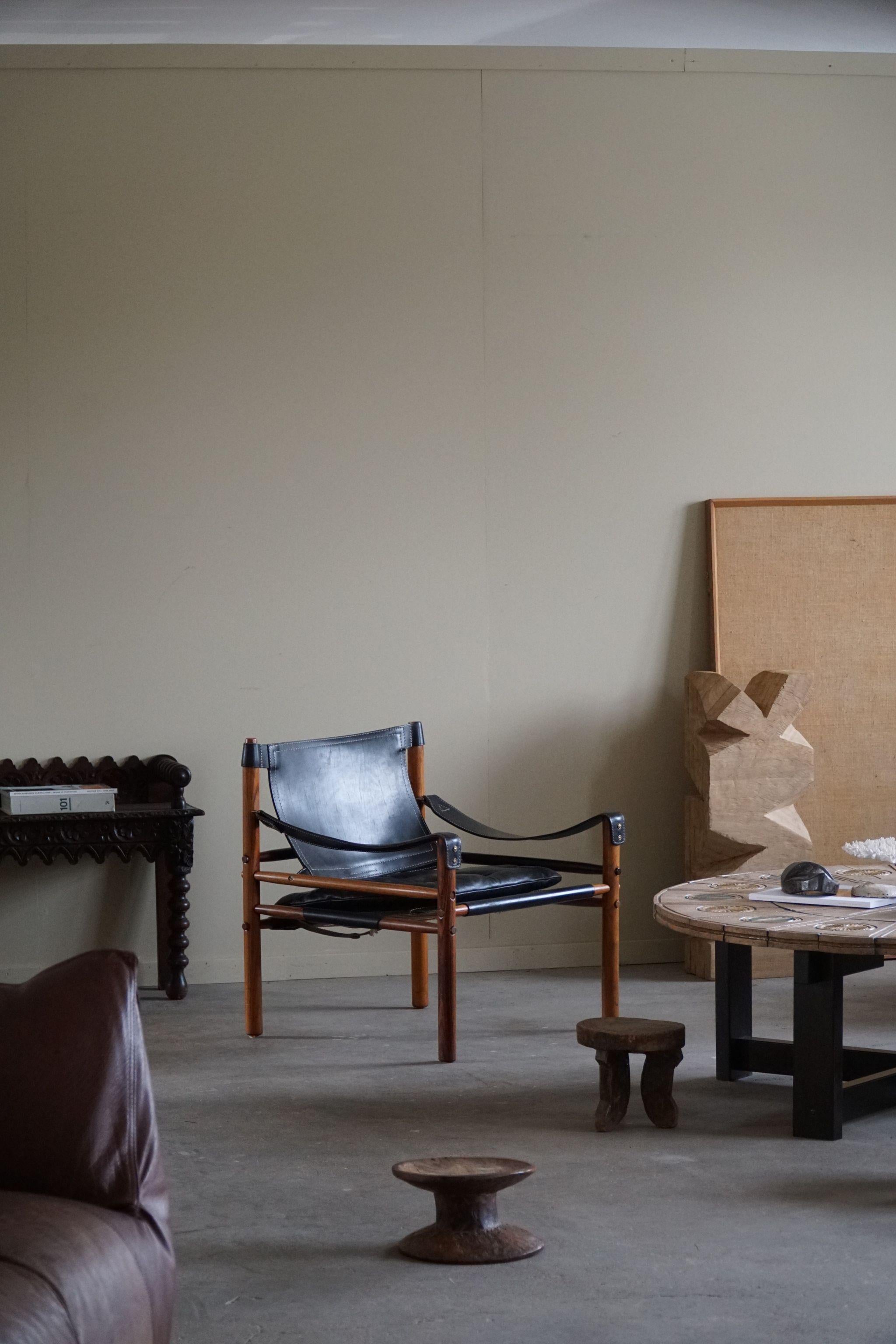 Une belle paire de chaises safari en cuir noir et bois de rose. 
Conçu par Arne Norell, produit par Arne Norell AB à Aneby, en Suède, dans les années 1960.
Cet ensemble est dans un très bon état vintage.

Ces fauteuils attrayants s'intègrent dans de