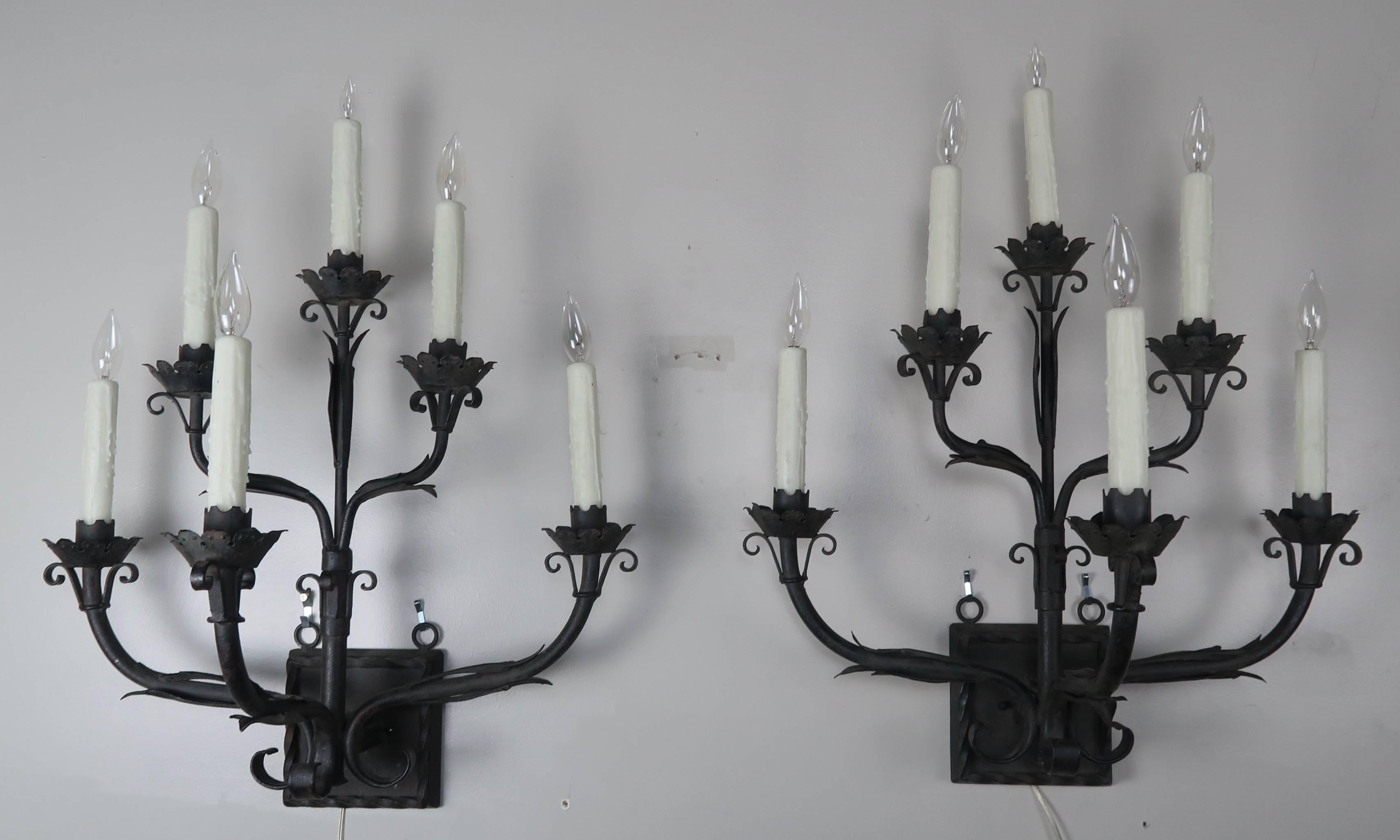 Pair of grand six-light Spanish wrought iron sconces. The pair of sconces has been newly rewired with drip wax candle covers and are ready to install.