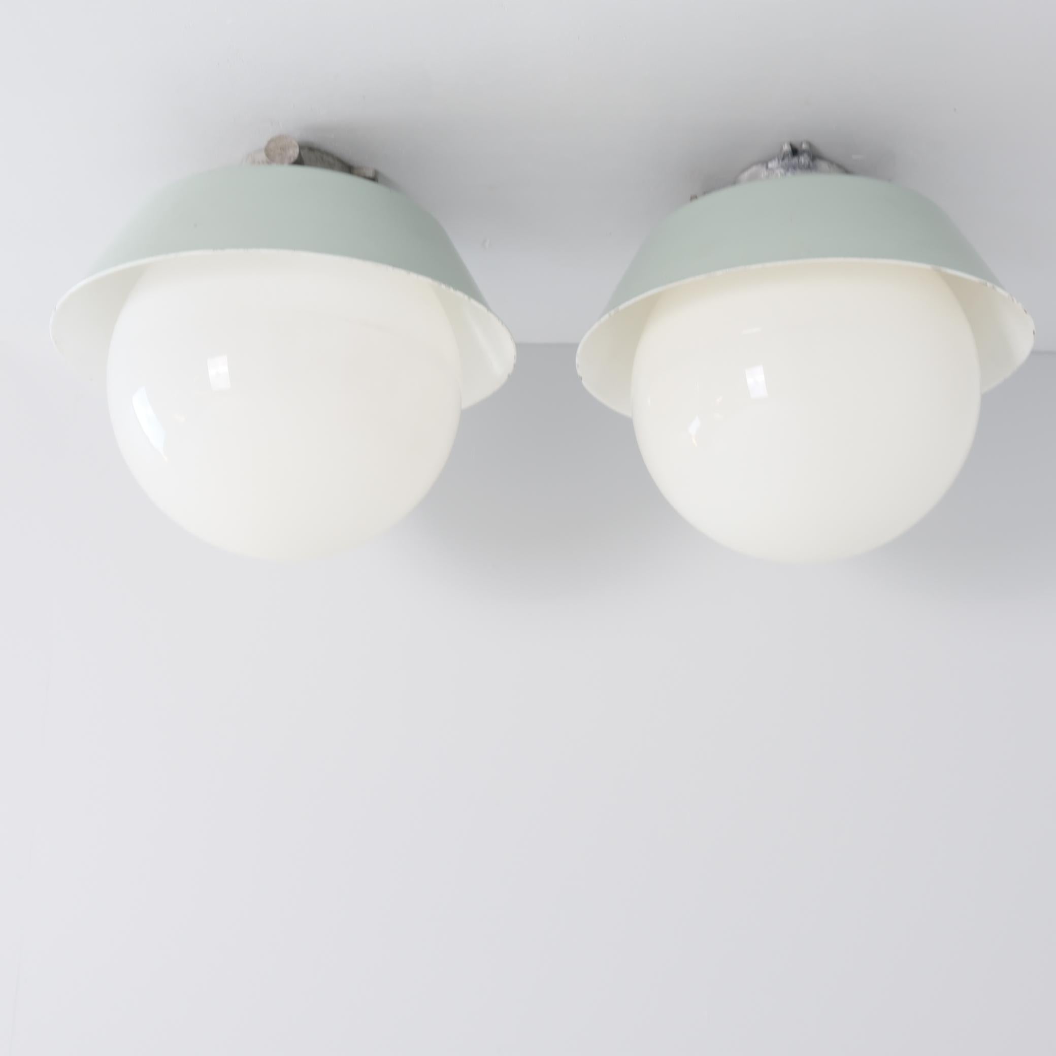 Un par de grandes lámparas Paavo Tynell de estilo industrial para exterior / interior. Estas lámparas modelo 2421-2453 son bastante grandes y tienen una gran pantalla esférica de cristal opalino que se enrosca y desenrosca fácilmente para cambiar la