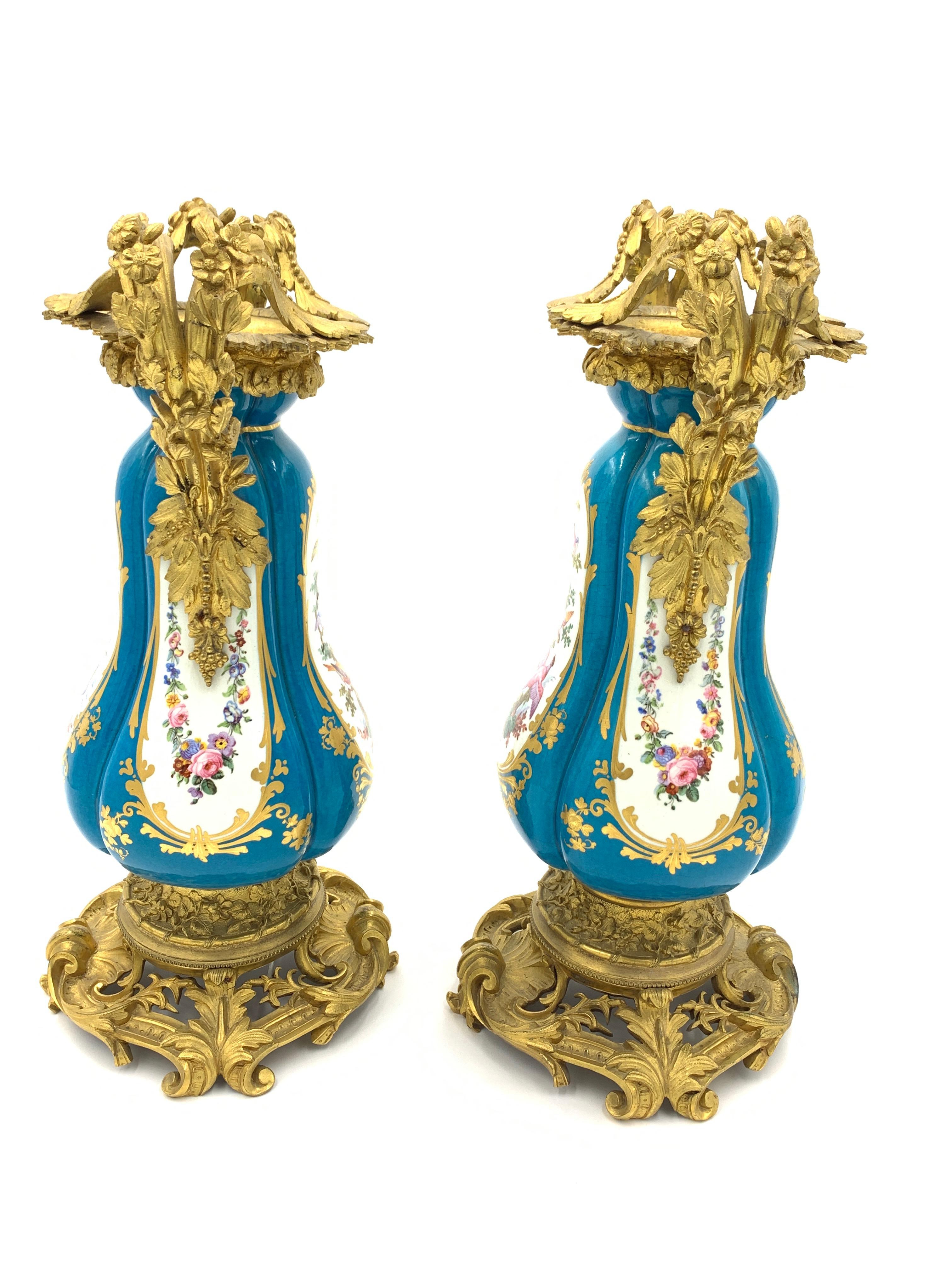 Fine sky blue sevres style vases with gilded ormolu mounts around the neck, sides and the base, the pictures in the vases depicts three birds on a tree with leaves around them.
 