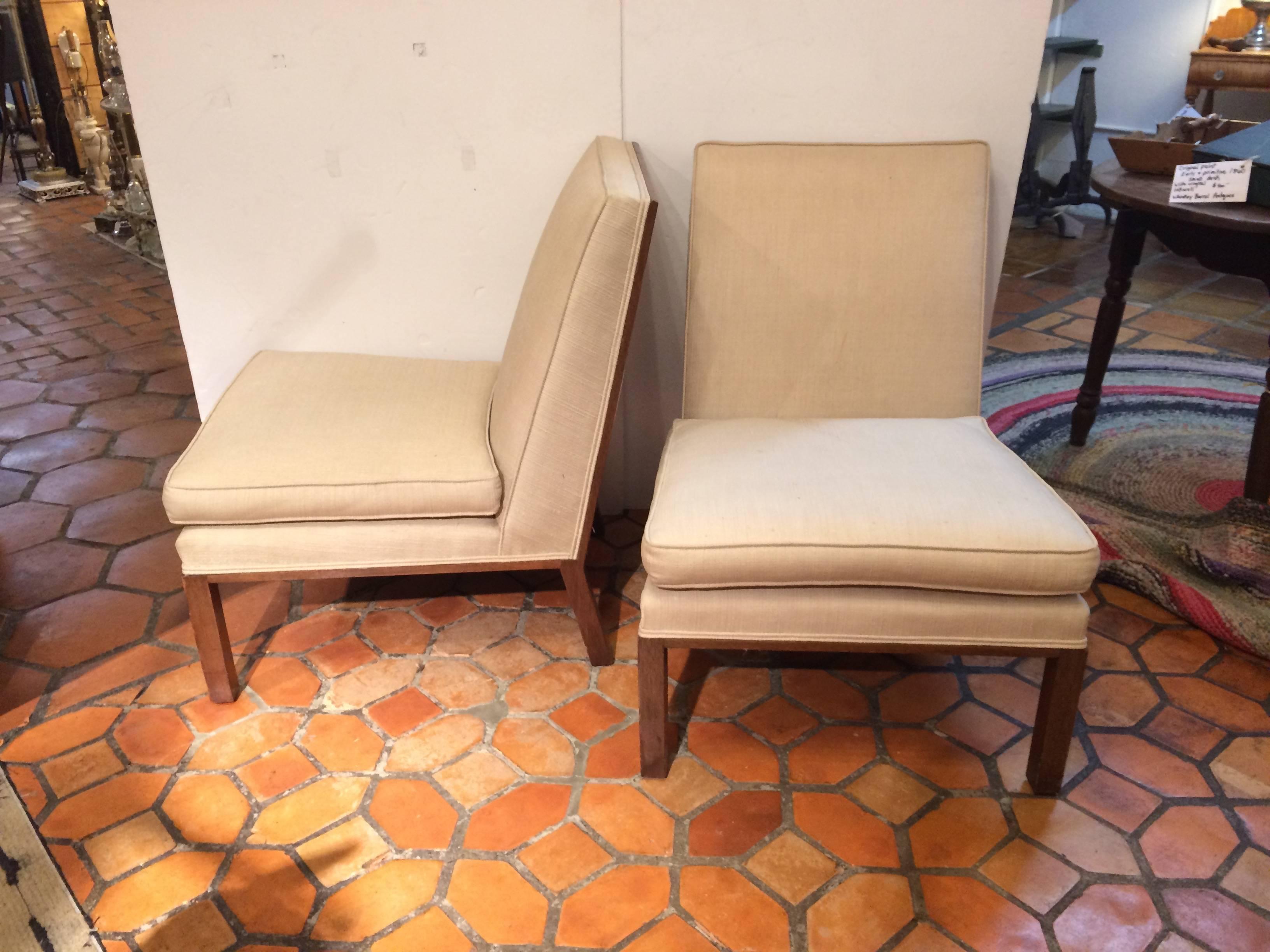 Two classically designed slipper chairs by Edward Wormley having mahogany bases and sleek upholstered Silhouette. The seat cushions are removable.