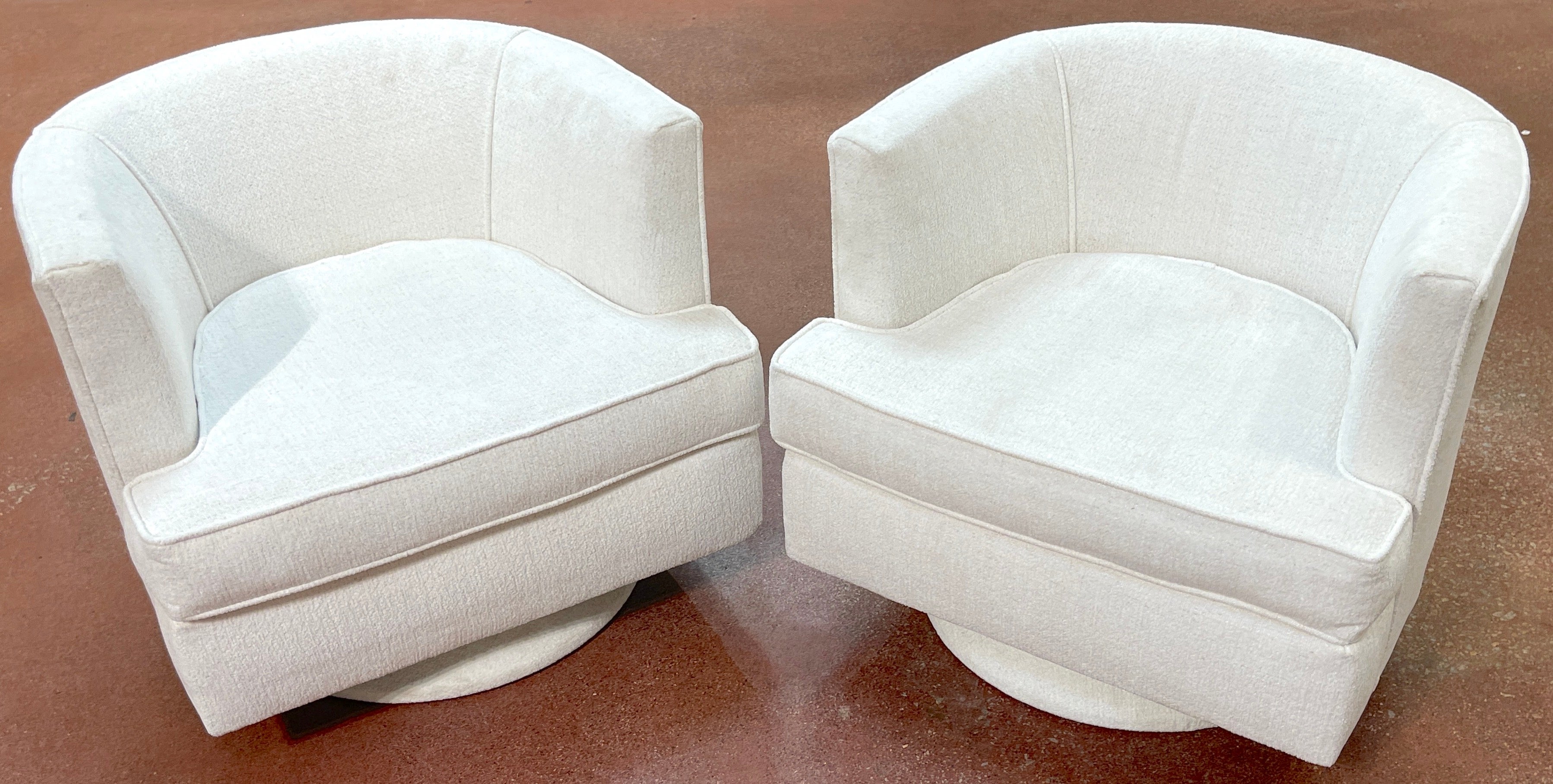 Paire de chaises pivotantes élégantes de style moderne du milieu du siècle dernier, tissu bouclé blanc Kravet, C. 1970
Style de Milo Baughman, États-Unis, années 1970

Cette paire de fauteuils pivotants élégants et modernes du Mid-Century reprend le