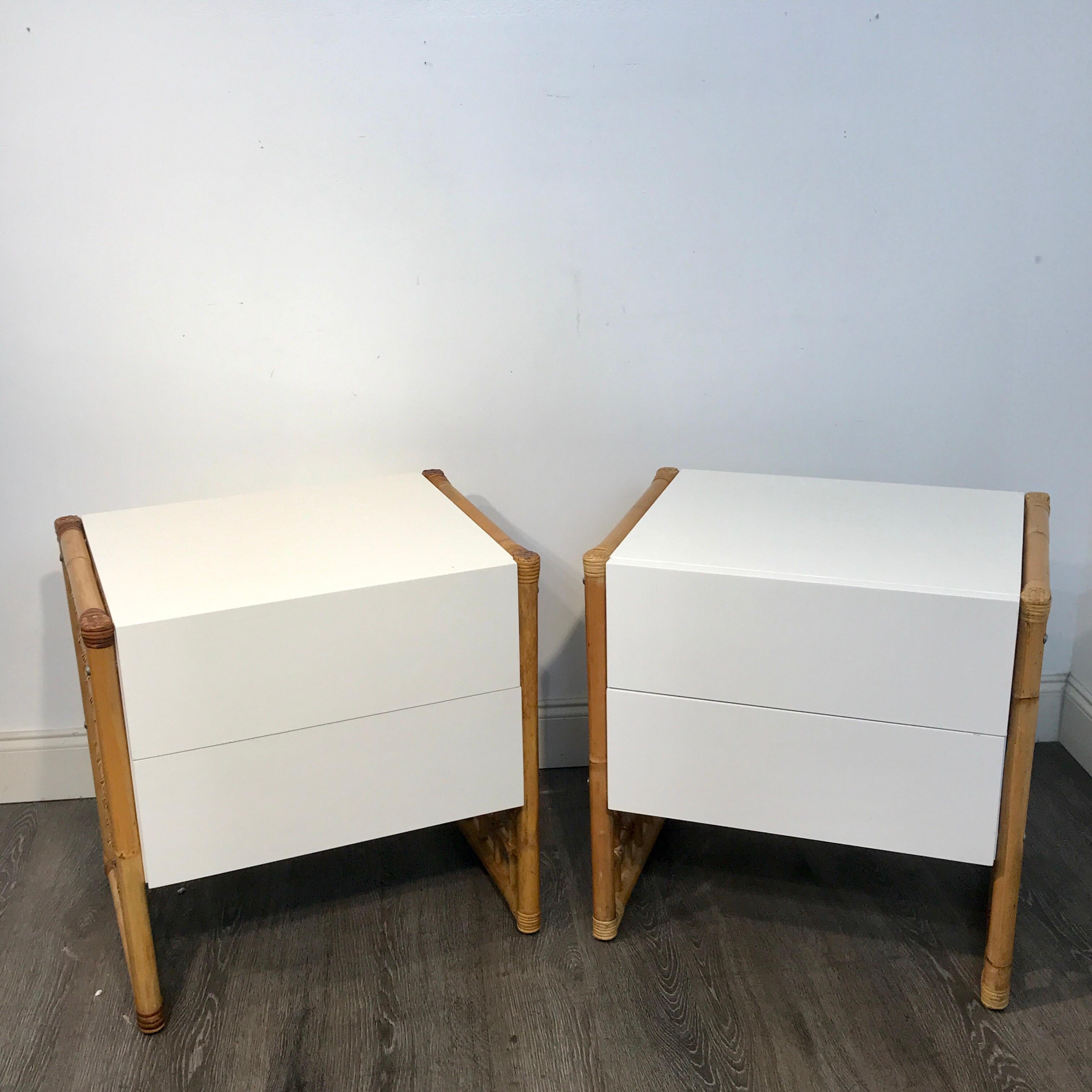 Pair of modern white lacquered and rattan end tables or nightstands, each one of cube form with flanking rattan, reed and willow grid legs. Fitted with two 12