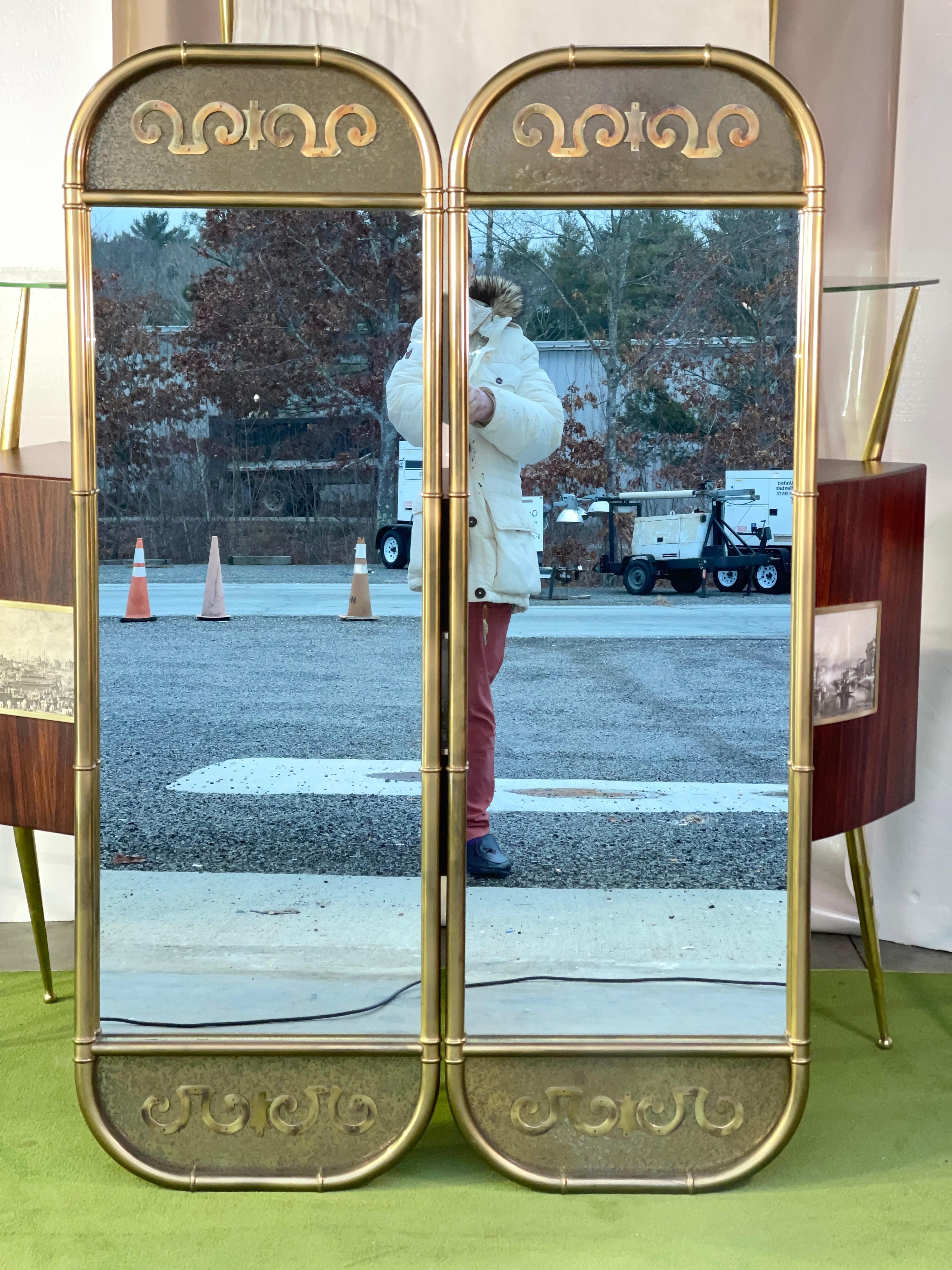 Pair of vertically oriented tall and narrow racetrack oval wall mirrors by Mastercraft in solid brass frame with faux bamboo elements and distinctive brass appliqué motif on textured and patinated brass panels. Sold as a pair.

See our separate