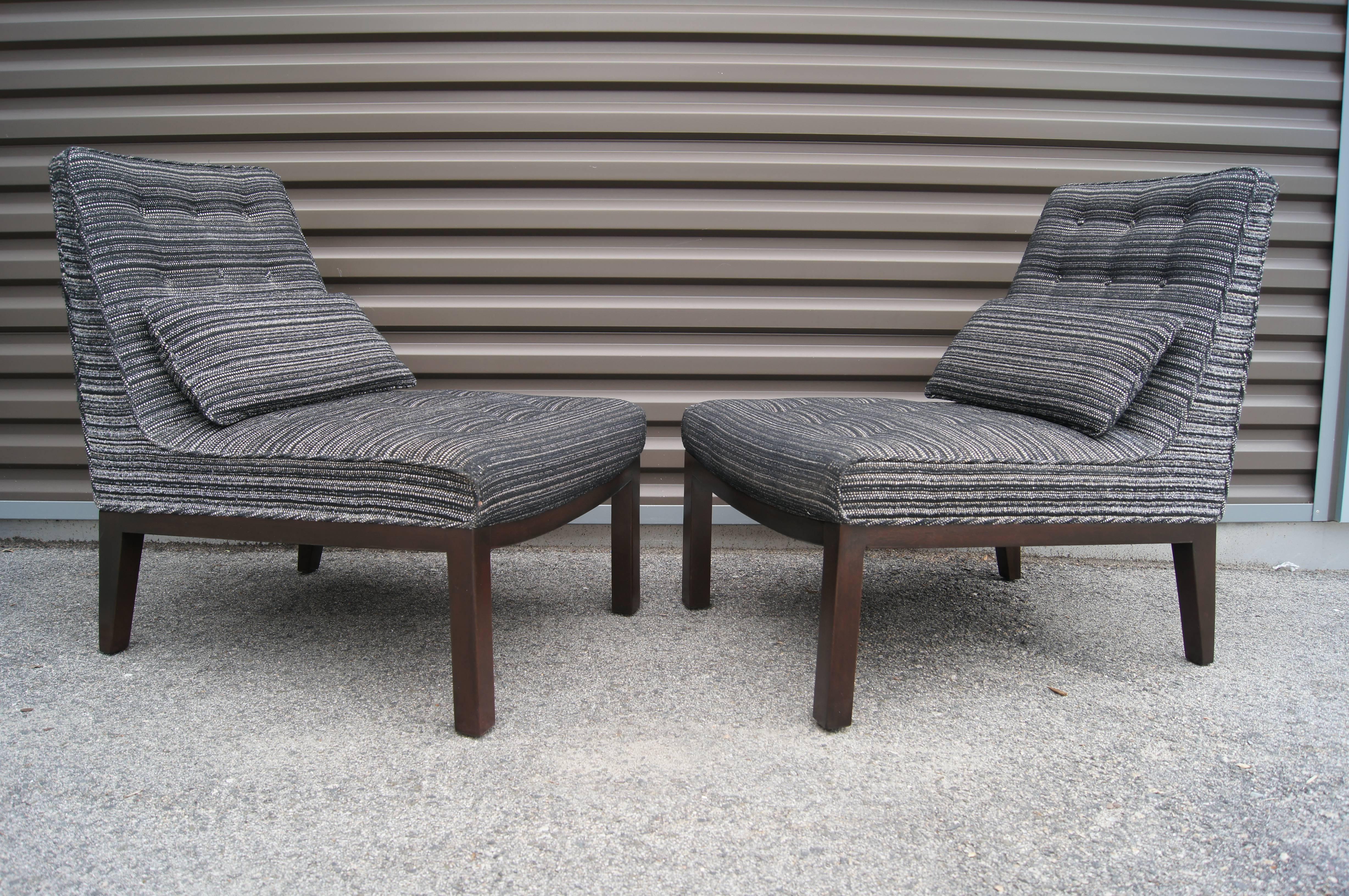 Edward Wormley designed these armless lounge chairs, model 5000-A, as part of Dunbar's Decorator Group. Their mahogany base contrasts handsomely with the buttoned upholstery of the comfortable seat and back.