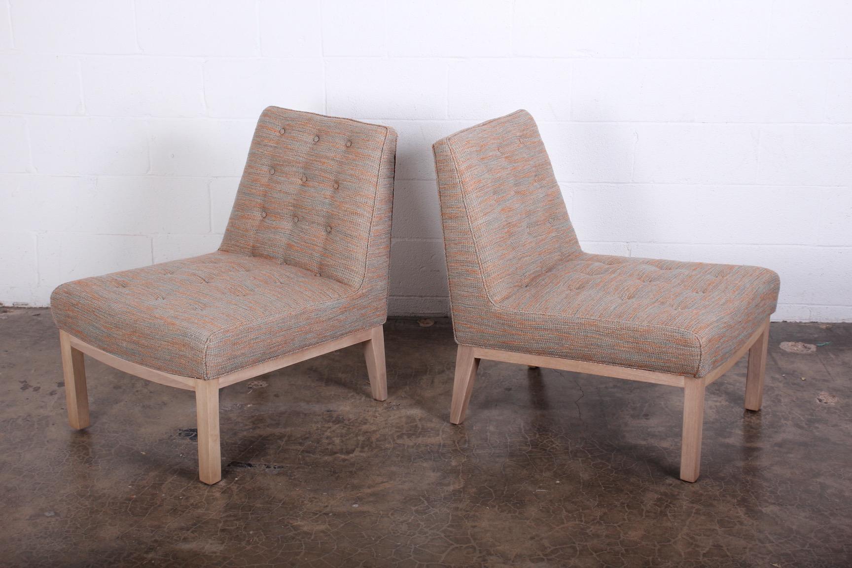 A pair of slipper chairs with bleached mahogany bases. Designed by Edward Wormley for Dunbar.