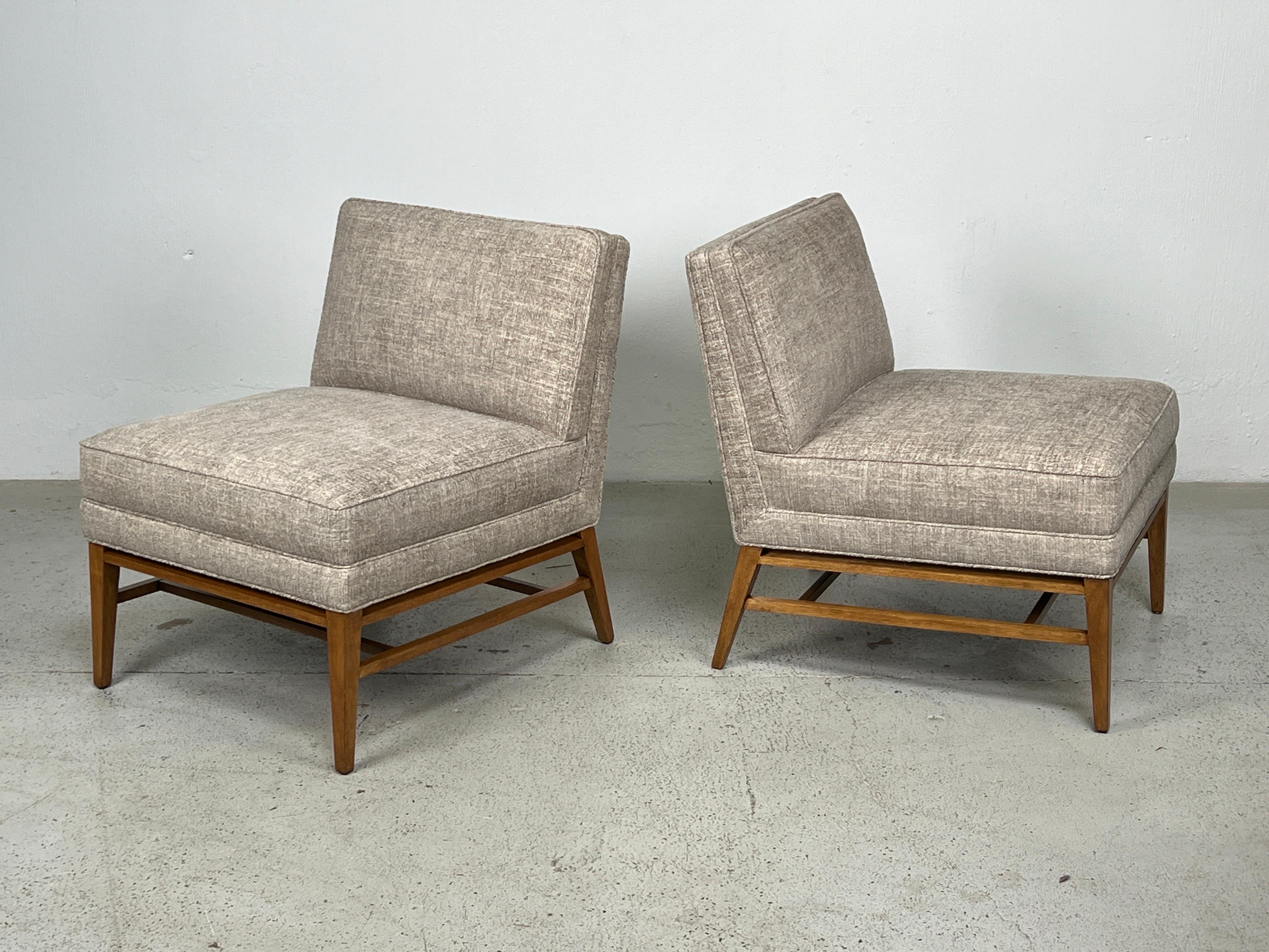 A pair of Paul McCobb slipper chairs with maple bases. 
