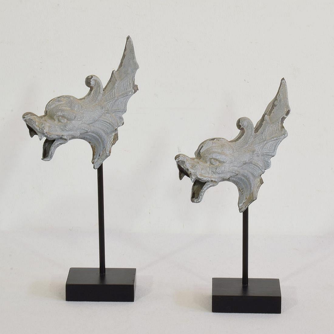 Rare pair of zinc fragments representing mythical figures/ gargoyles. They once graced a rich facade of a building,
Original period pieces, France, circa 1850-1900.
Weathered. Measures: H: 22-26cm W: 13cm D: 11cm 
Measurement includes the wooden