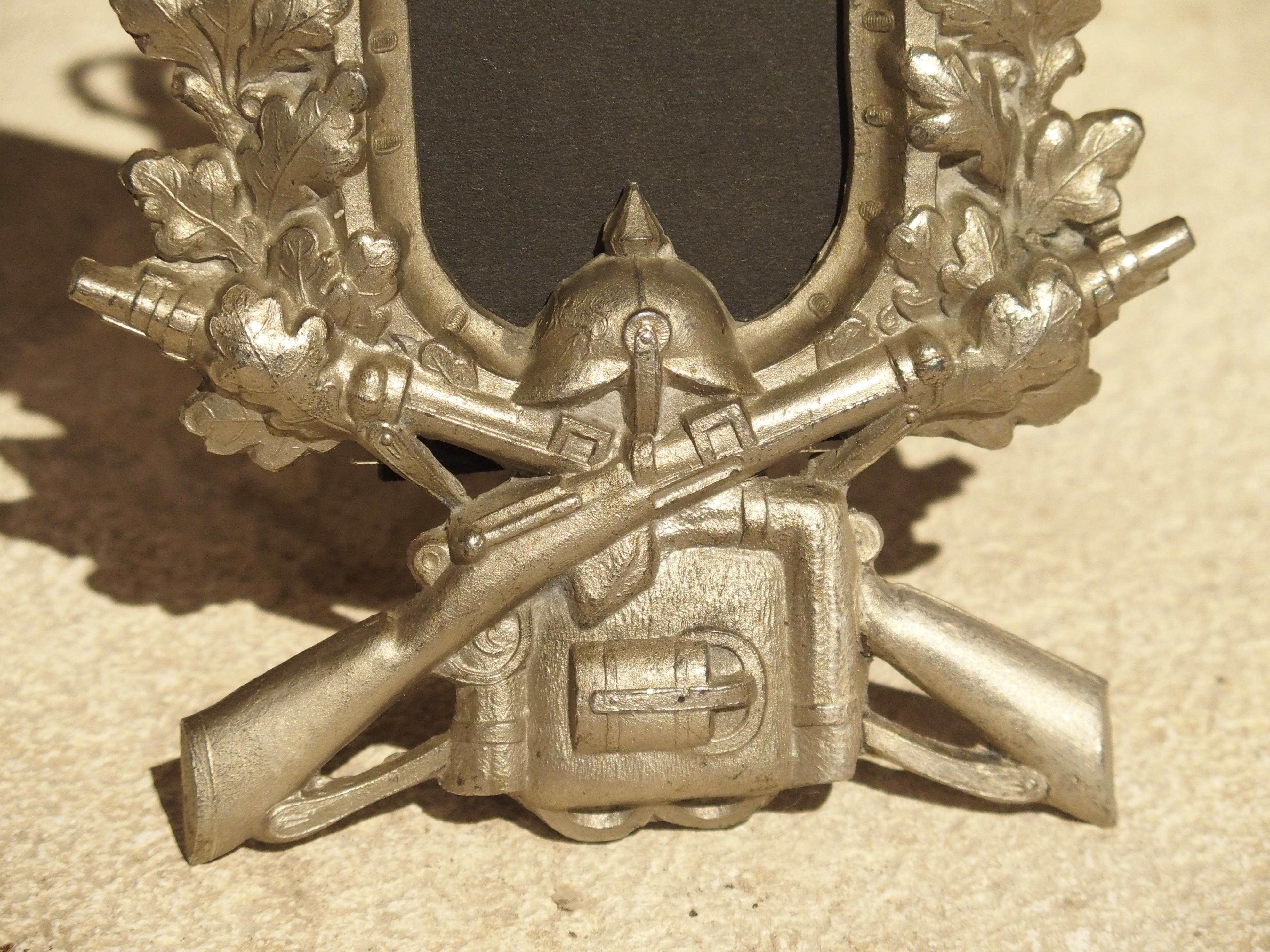 These small and unusual German picture frames are adorned with several decorative motifs. They include a crown and cross with 2 coat of arms military banners draped over spears. Beneath, are large oak leaves over a helmet, two crossed rifles, and a