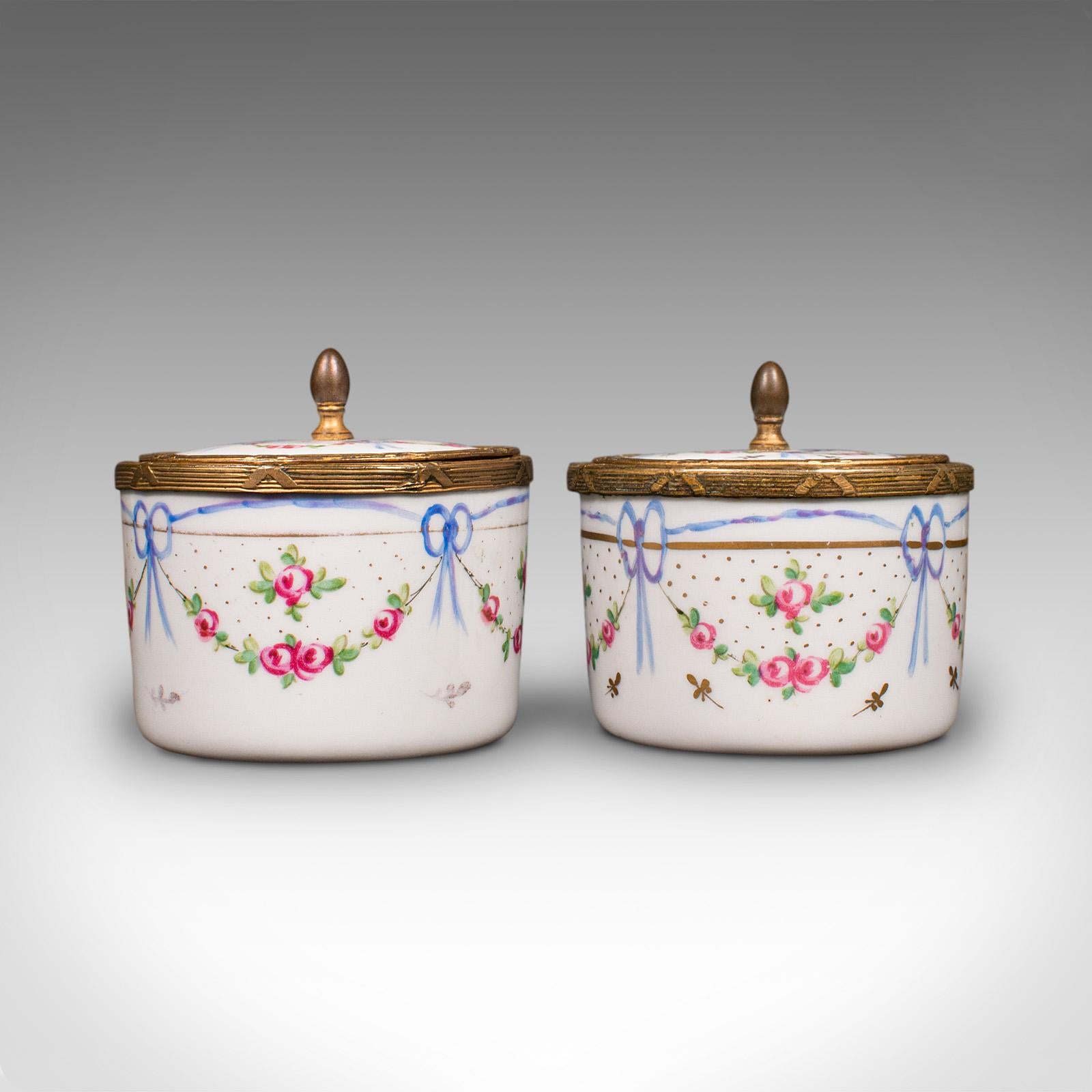 This is a pair of small antique dressing table pots. An English, hand-painted ceramic vanity dish, dating to the late Victorian period, circa 1900.

Delightfully finished vanity pots, with charming decorations
Displaying a desirable aged patina with