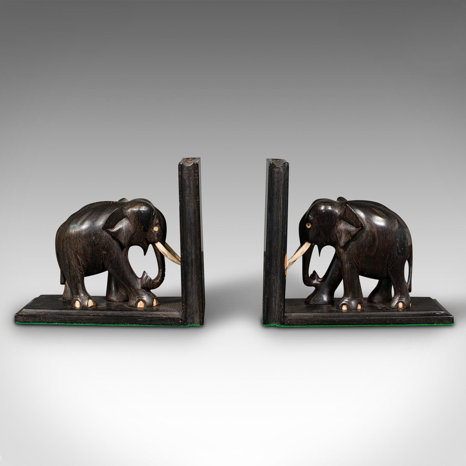 Dies ist ein Paar von kleinen antiken Elefanten Buchstützen. Eine anglo-indische, aus Ebenholz und Knochen geschnitzte Roman- oder Buchablage aus der späten viktorianischen Zeit, um 1890.

Ausgestattet mit reichlich Charakter und Appell an den