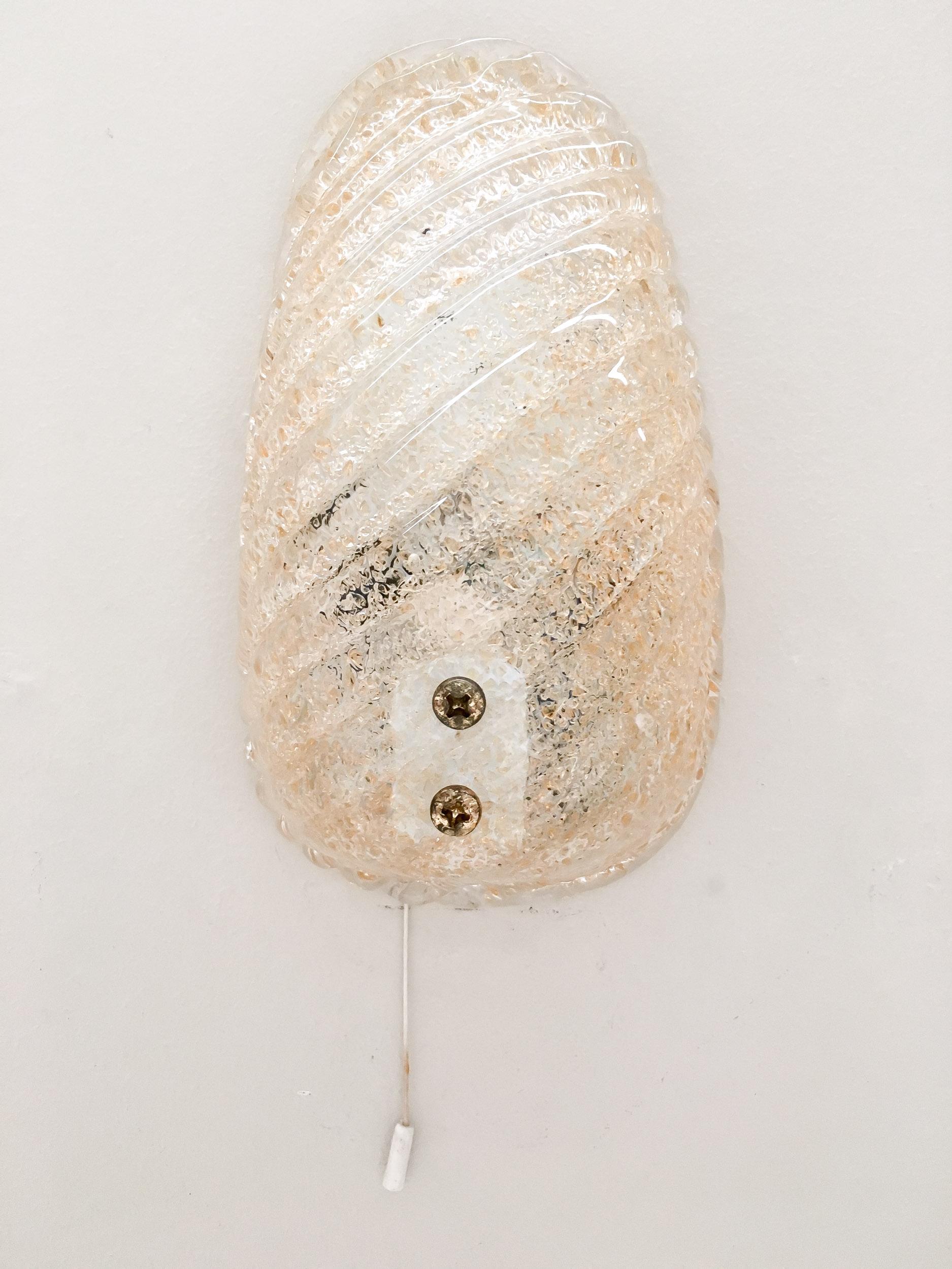Una squisita coppia di appliques in vetro di Murano color oro della leggendaria Barovier&Toso, un nome sinonimo di secoli di maestria del vetro di Venezia. Realizzata con eccezionale maestria, ogni applique emette una luce calda e radiosa che