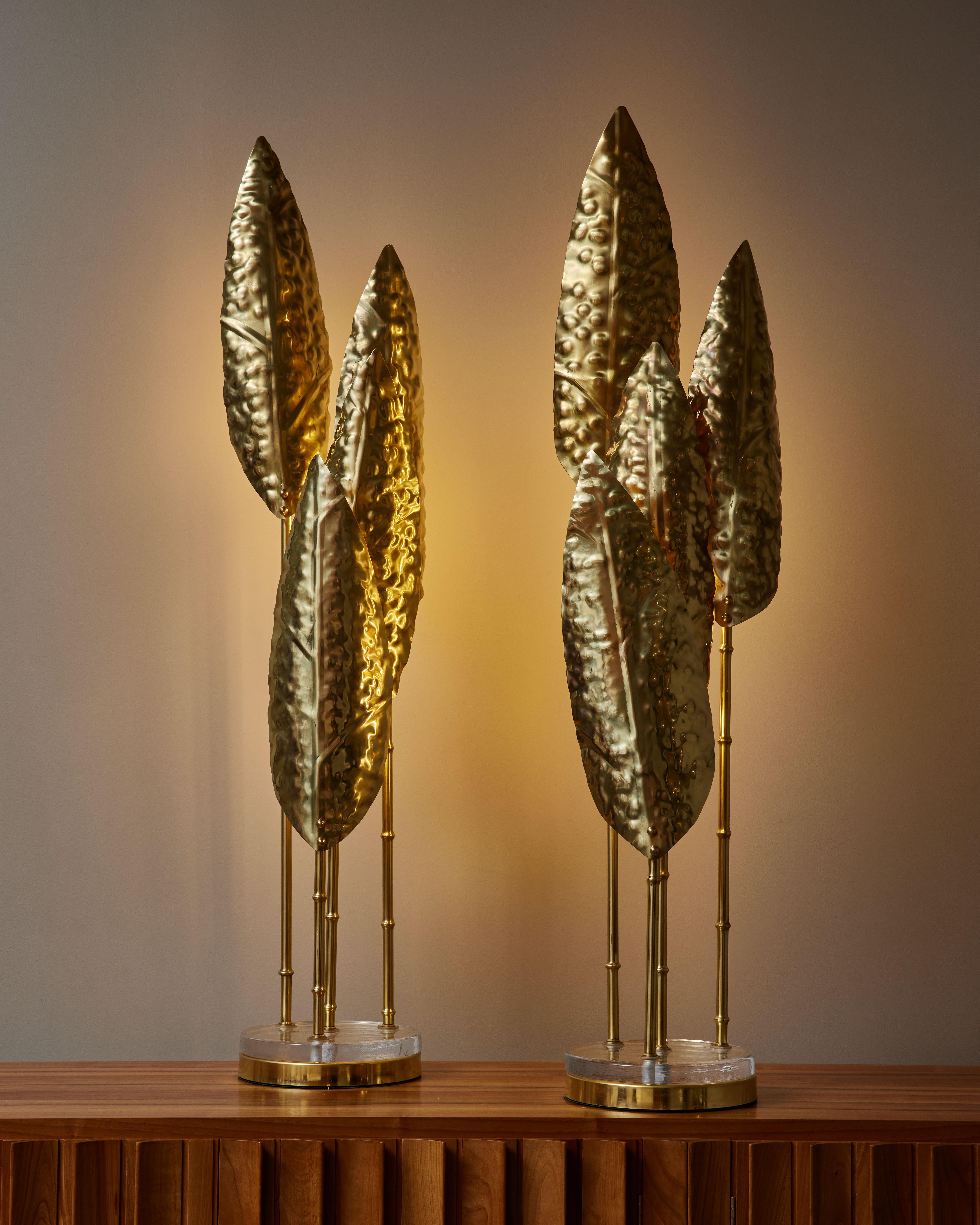 Pair of decorative floor lamps made of a round brass and clear glass foot, four bamboo shaped stems and elongated leaves each hiding one source of light.