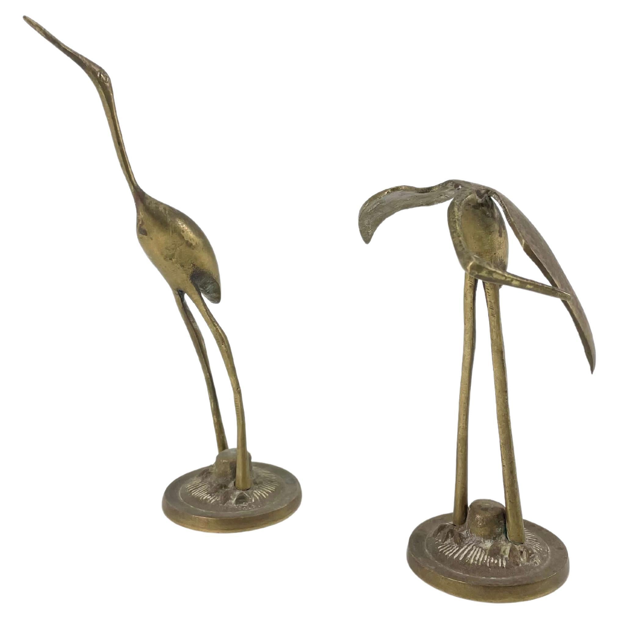 A set of two beautiful vintage brass crane or heron statues. This decorative item would make a beautiful addition to any table or display. Made in the 1960s, this pair display the joy of that great era with a bold, statement. They have a beautiful