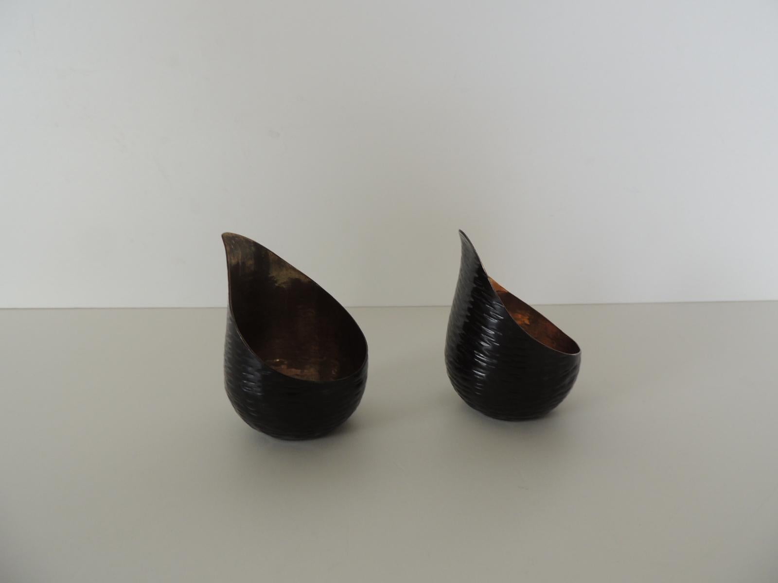 Pair of small brass modern tea light candle holders.
Shy black outside coated paint and polished brass interiors.
Made in India.
Size: 2.1/4