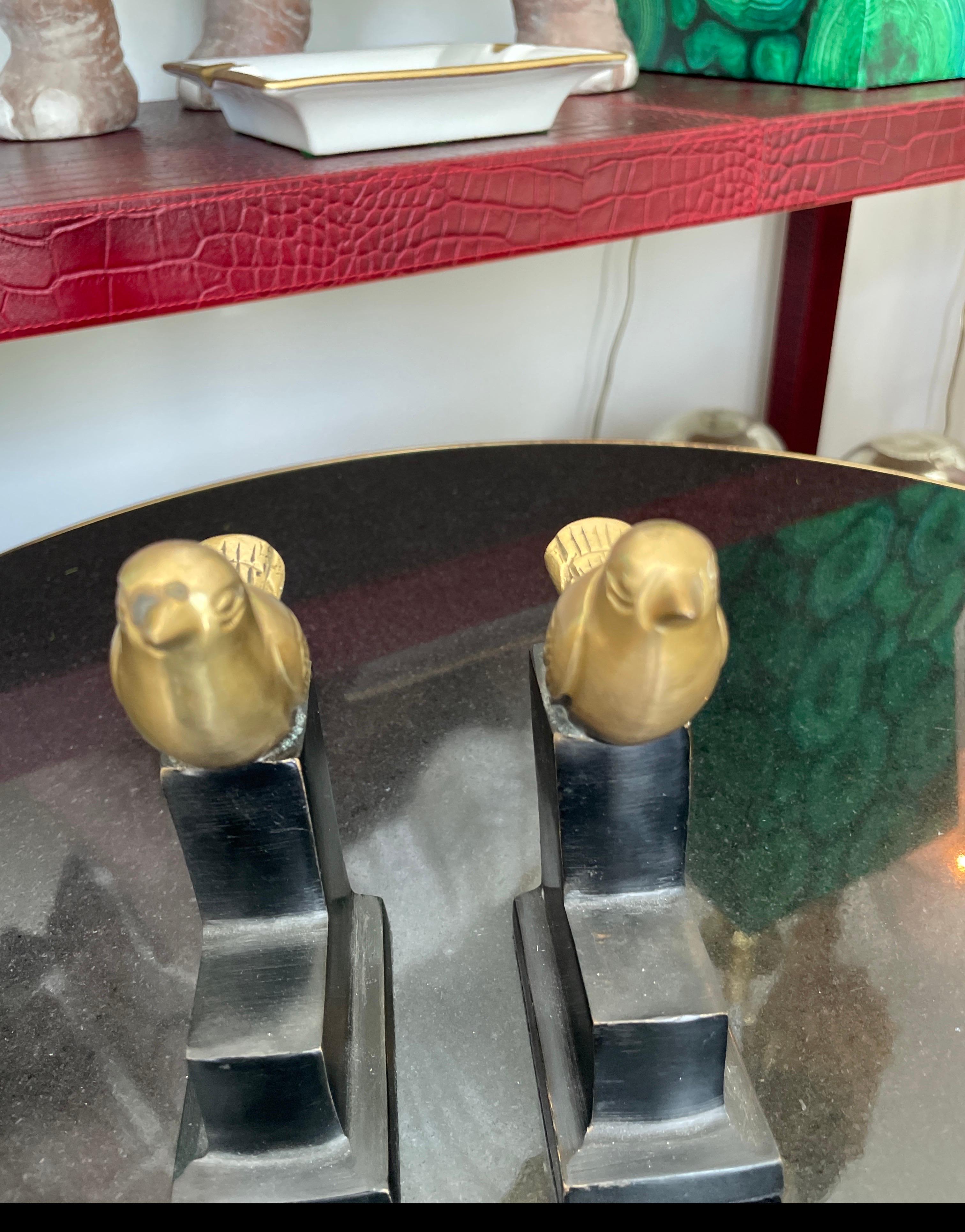 Pareja muy dulce de sujetalibros de pájaros de bronce dorado sobre bases de mármol escalonadas. 