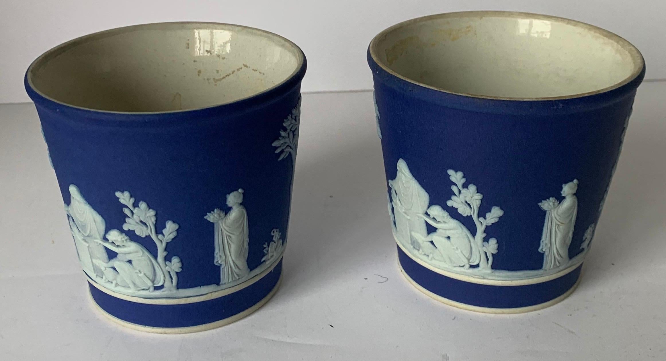 Pair of small dark blue Wedgwood Jasperware vases. Glazed interiors. Overall neoclassical motif. Stamped on the underside.