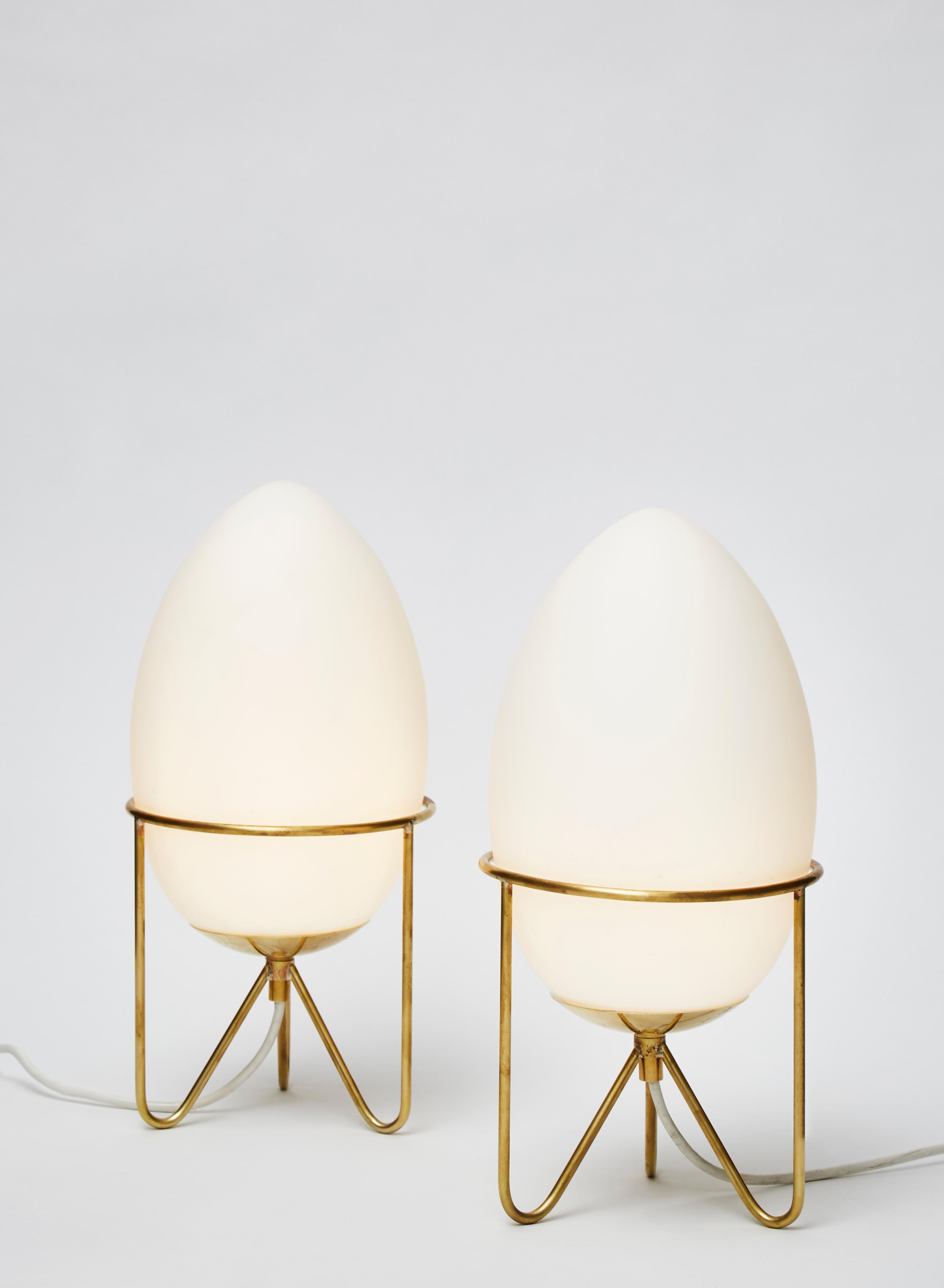 Pair of small table lamps, ideal for bedside tables, made of a frosted glass white egg shaped globe sat on brass feet.