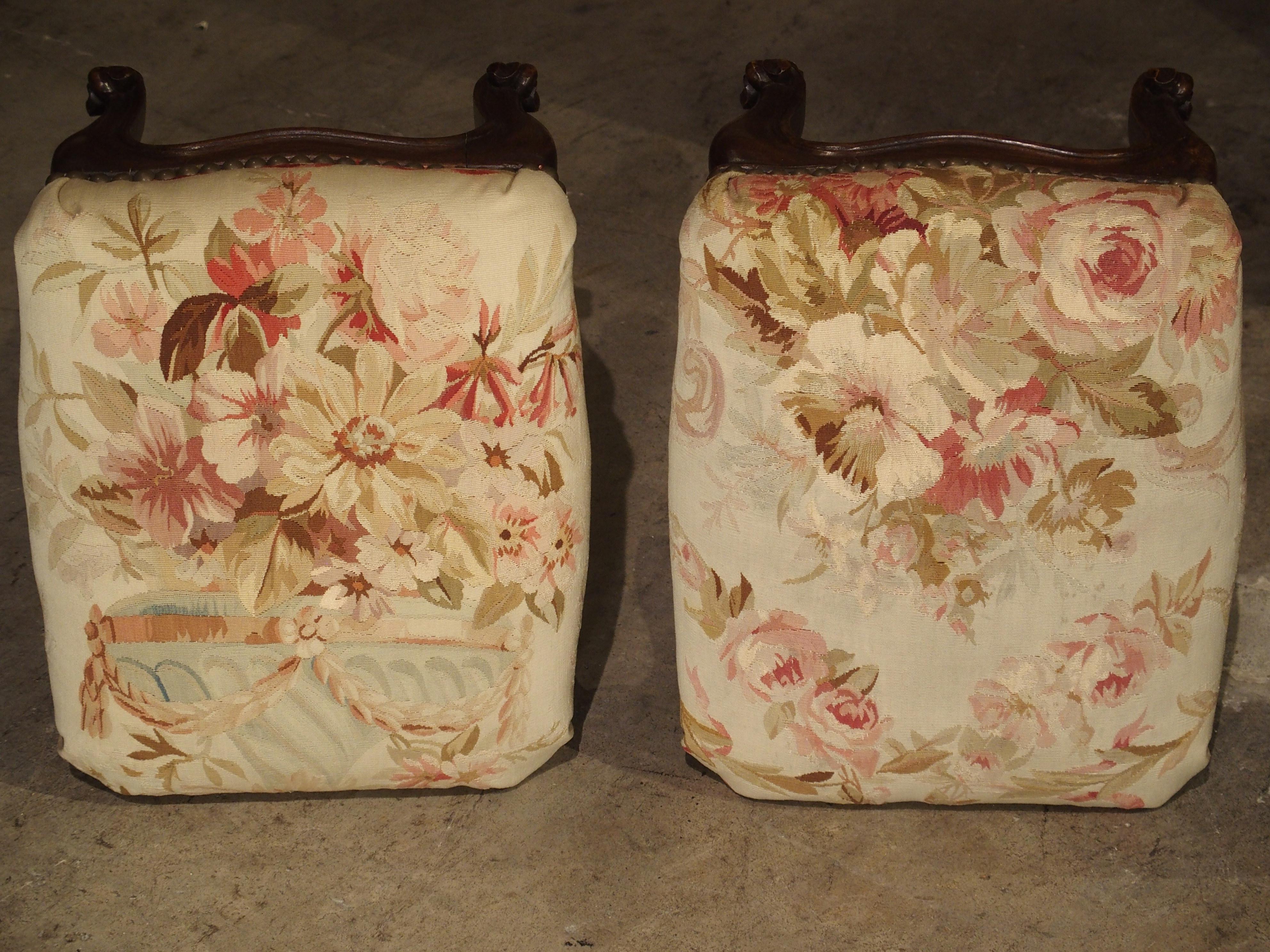 From France, this beautiful pair of Louis XV Style footstools have been upholstered in antique flat-woven Aubusson. This type of Aubusson fabric was primarily used for very large chateau room size rugs as well as custom upholstery. The silk and wool