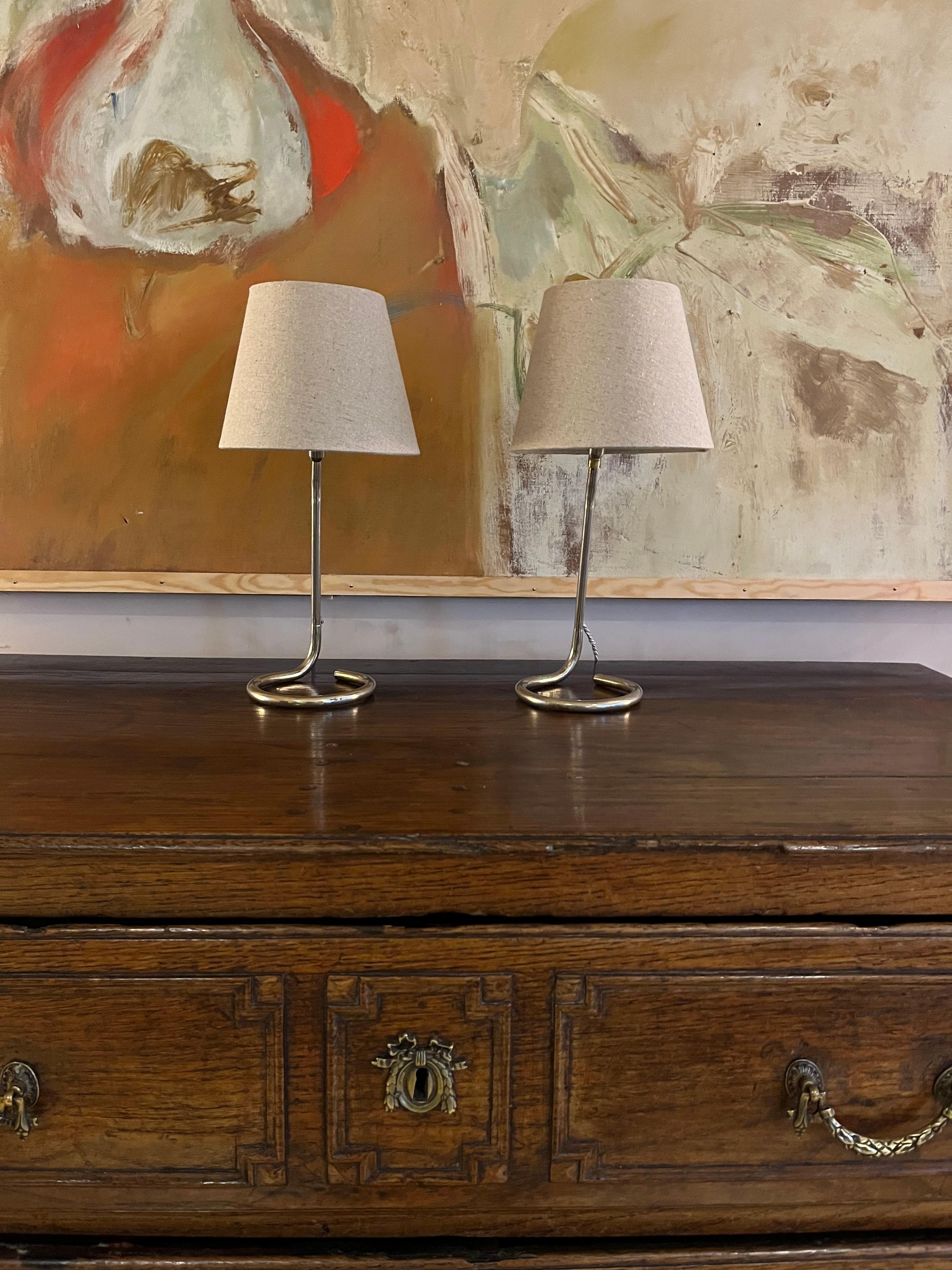 A pair of small nickel table lamps. Small difference to the light fitting. Rewired with silver silk flex. Gréât as table or bedside lamps. 