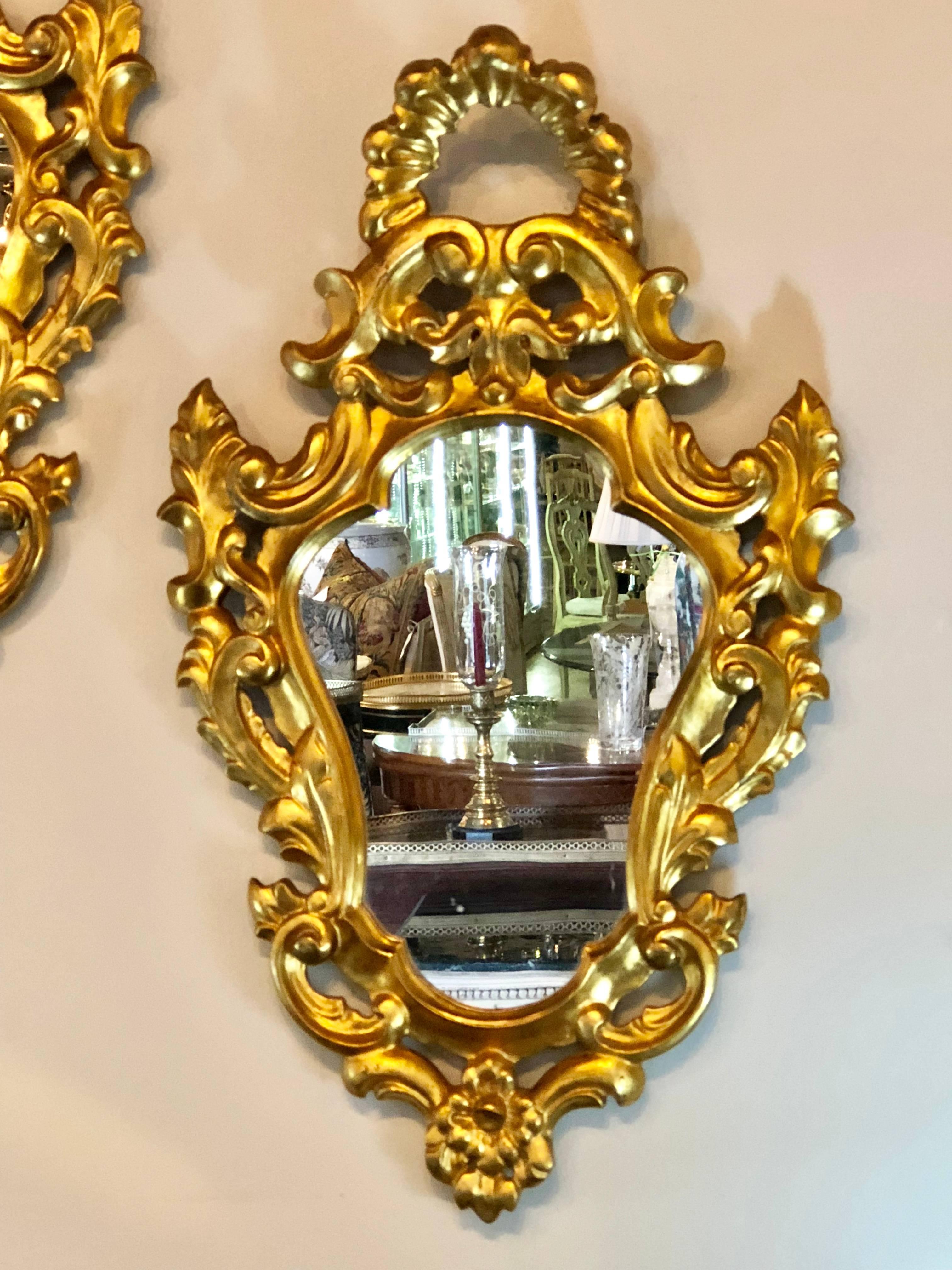 Pair of small giltwood Italian Rococo style wall mirrors. Each frame with wonderfully carved roses and scrool designs. From a fine NYC apartment.