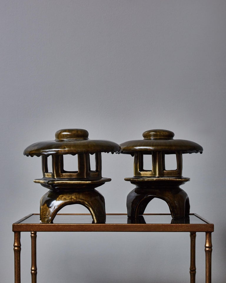 Pair of charming little table lamps shaped like pagodas, glazed in dark green with accents of beige and brown.
