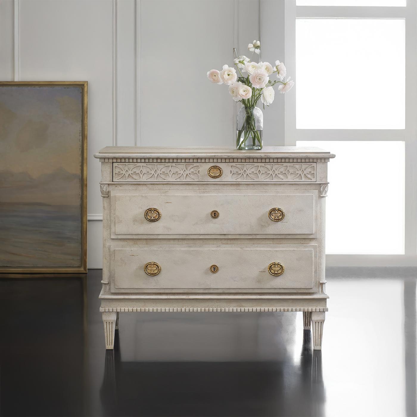 Bedside chests elegantly combine classical Swedish design elements with refined architectural details. The antique painted finish provides an authentic patina, while dental moldings and blind fret carvings showcase traditional Gustavian