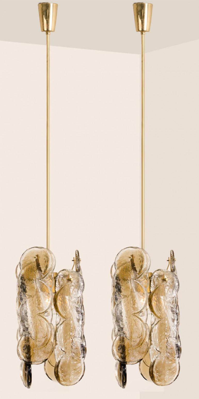 Une paire de superbes lampes suspendues en verre de Murano par Kalmar, années 1960. Verre à glace tourbillon fumé de haute qualité, 6 panneaux en verre de cristal clair torsadé avec une bande de couleur ambre parsemée d'or clair.

Qualité lourde.