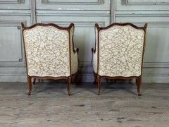 Pair of small Louis XV-style wingback chairs in carved walnut, stamped by Bosson