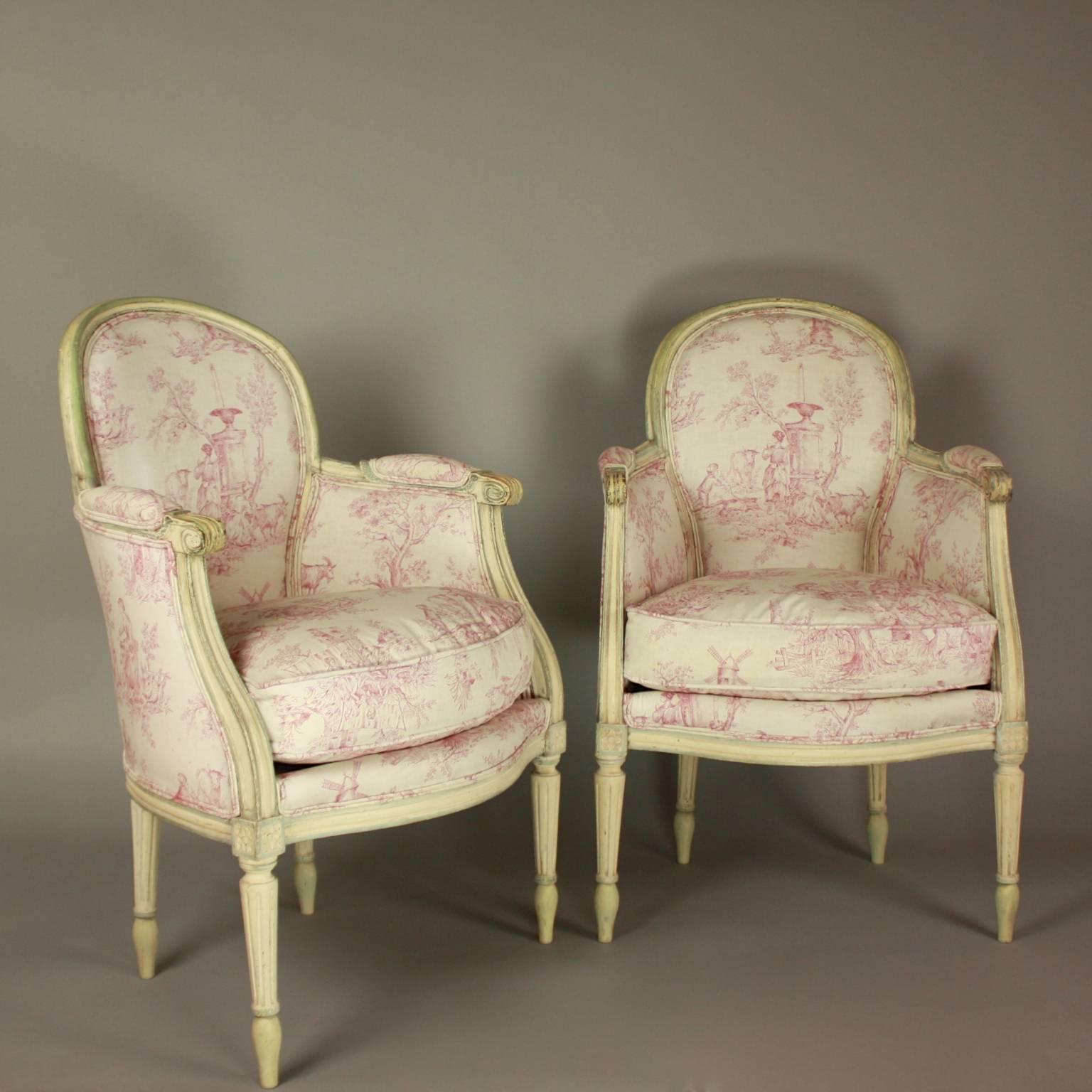 Pair of French 19th Century Louis XVI Style Painted Wood Armchairs or Bèrgères

A pair of small Louis XVI style armchairs or 'bergeres en cabriolet' from the late 19th century. The carved paintwood bergeres with arched padded backs and loose cushion
