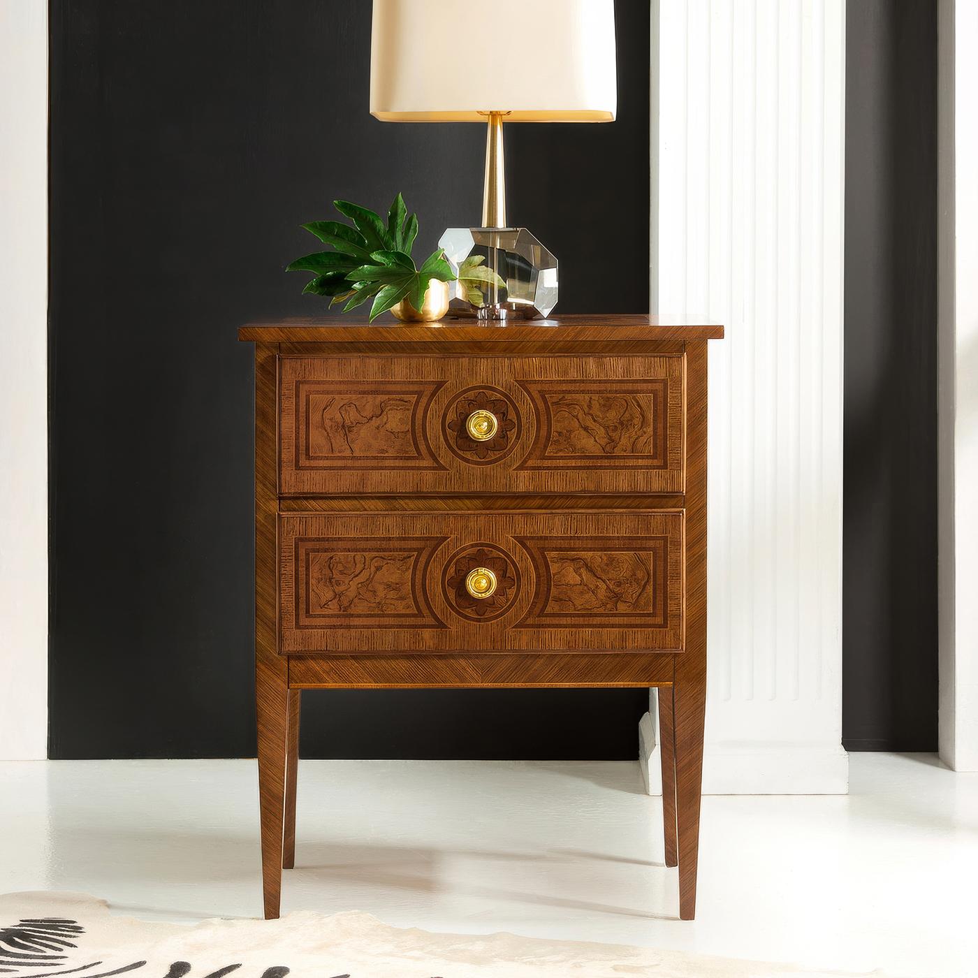 Nightstand embodies the refined elegance of 18th-century French design through its masterful use of book-matched burl veneers and delicate inlays. Each drawer front showcases symmetrically arranged burl patterns framed by precise stringing and cross